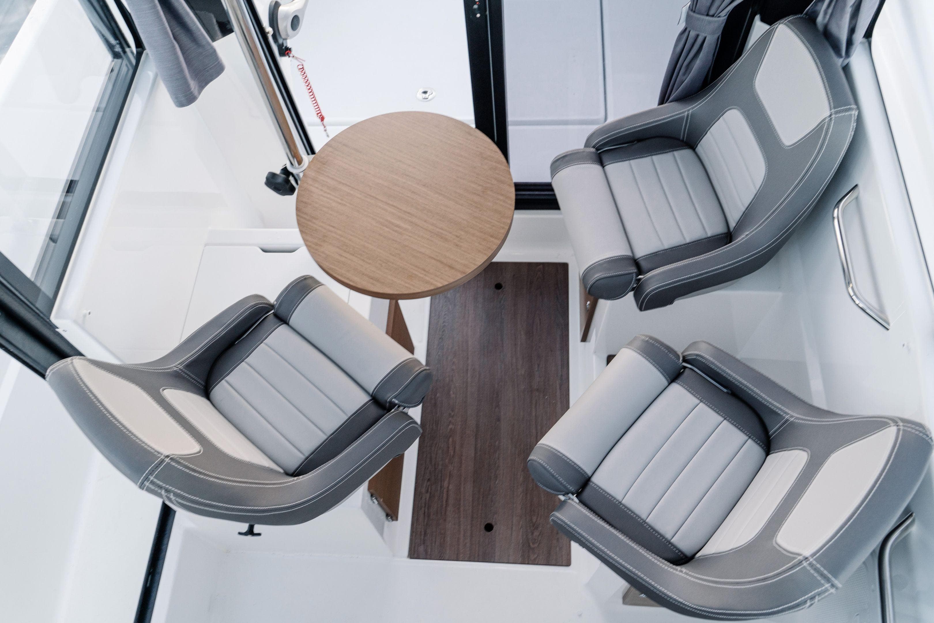 Interior of 2026 Jeanneau NC 695 Sport with modern seating and round table.