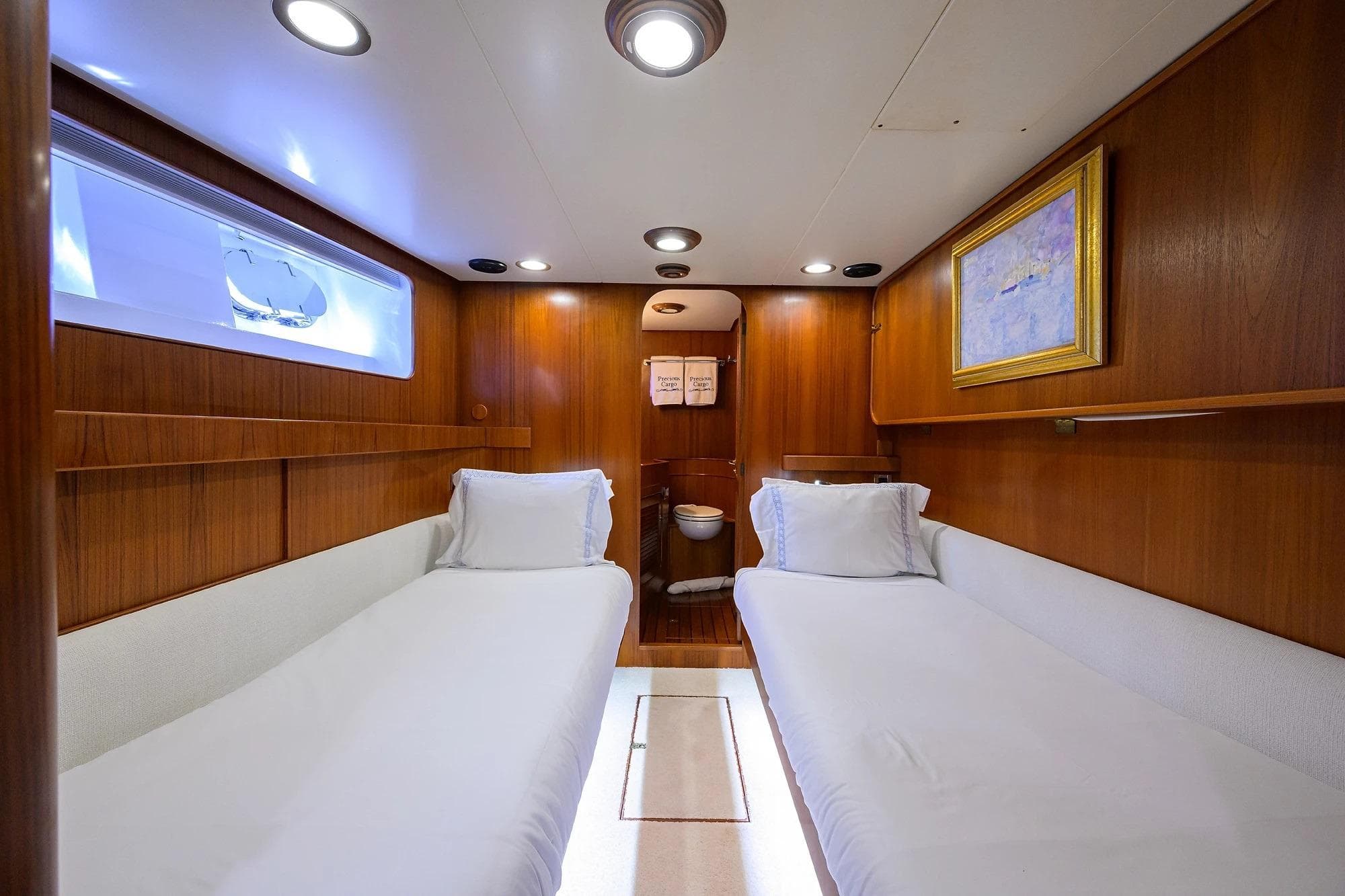 Luxurious 1986 Jongert 85 yacht cabin with twin beds and elegant wood paneling.