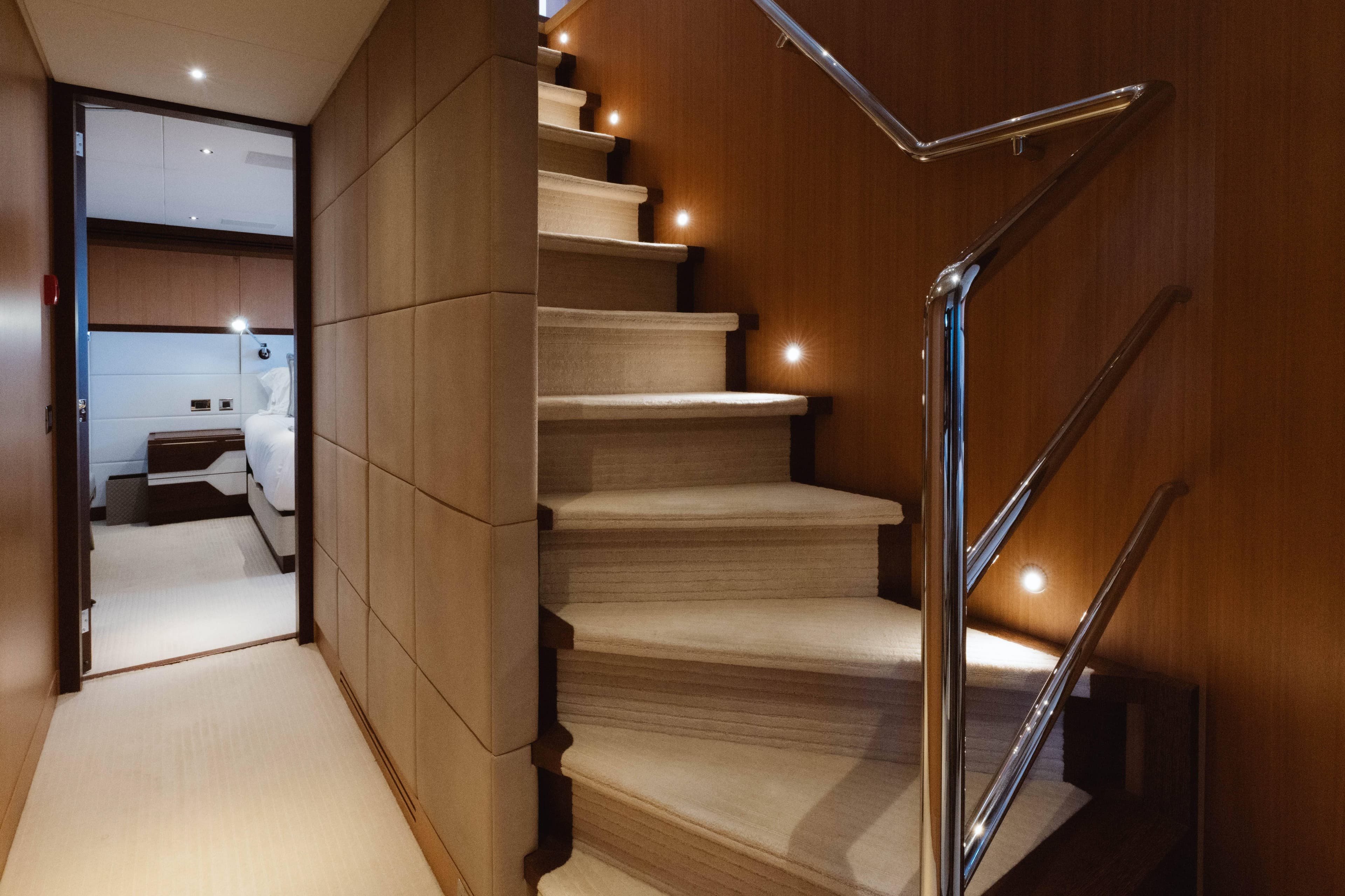 Luxurious interior of 2016 Feadship Lagoon Cruiser with elegant staircase and cozy bedroom.
