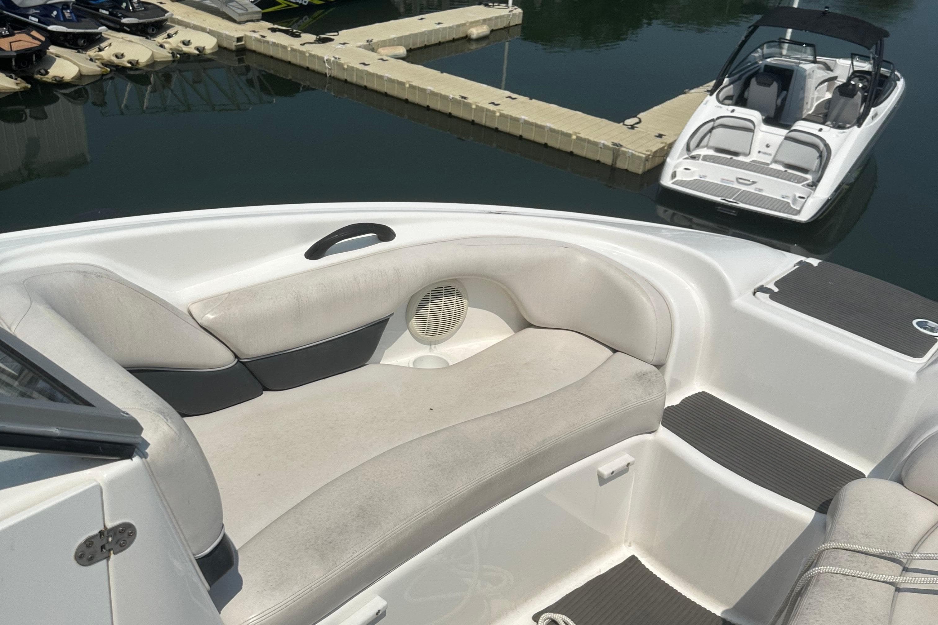 2007 Yamaha Boats SX210 interior with cushioned seating at a marina.
