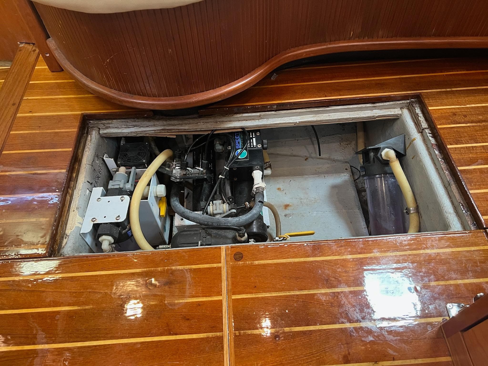 Engine compartment of a 1992 Endeavour 45 sailboat with wooden flooring.