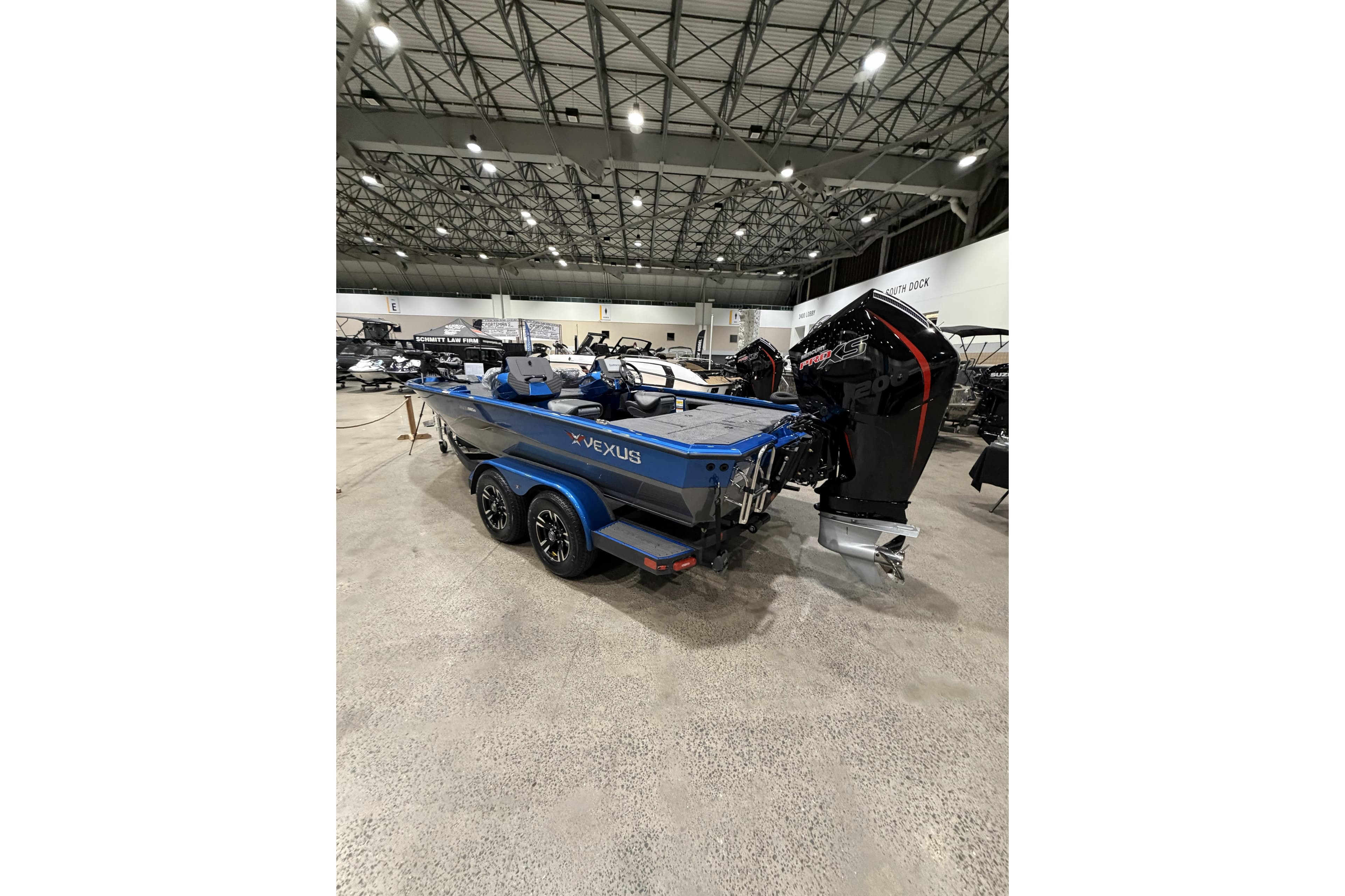 2026 Vexus AVX 1985s boat displayed indoors, featuring a sleek design and powerful engine.
