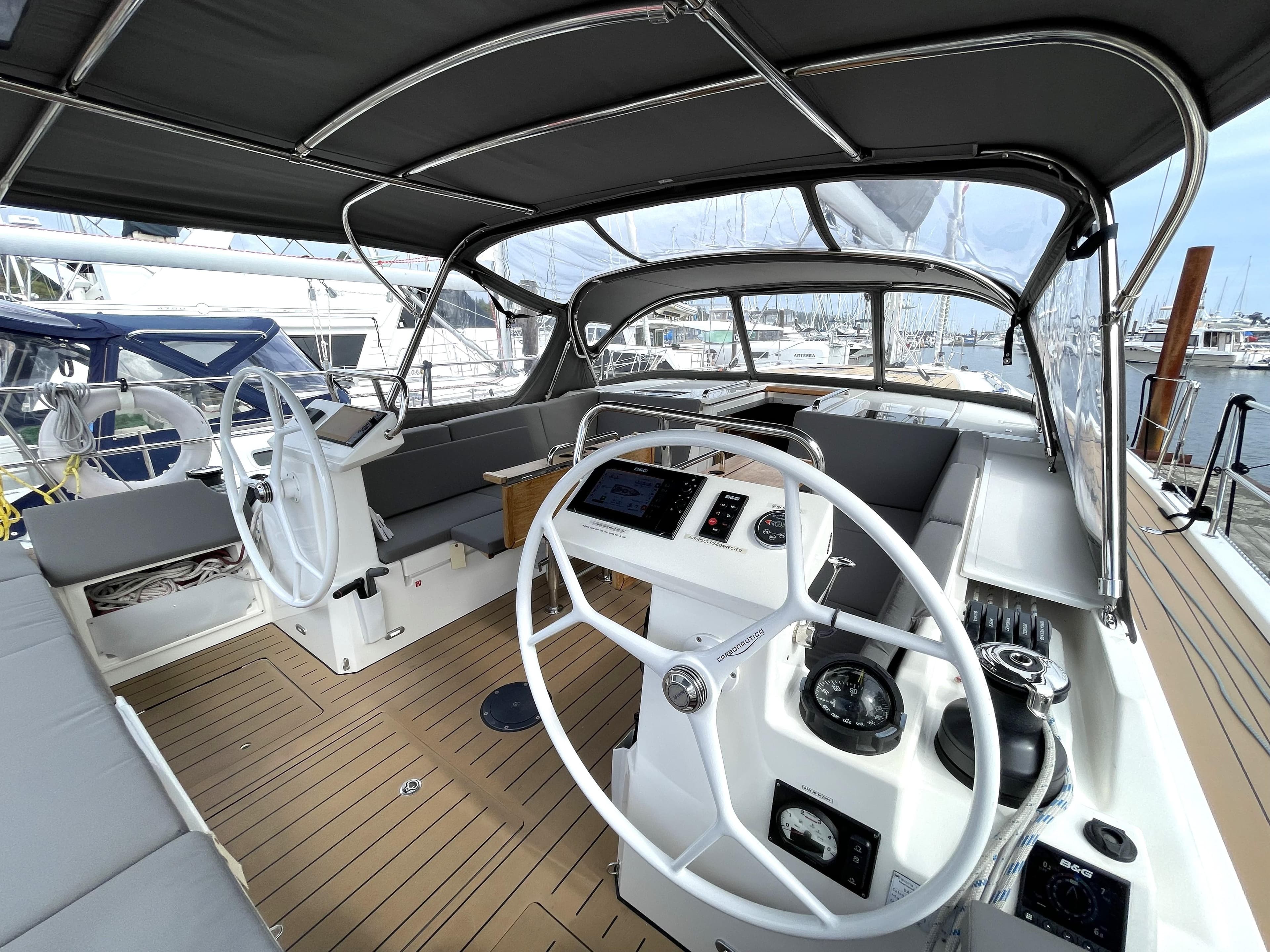 2019 Bavaria C45 Style yacht cockpit with dual steering wheels and modern navigation equipment.
