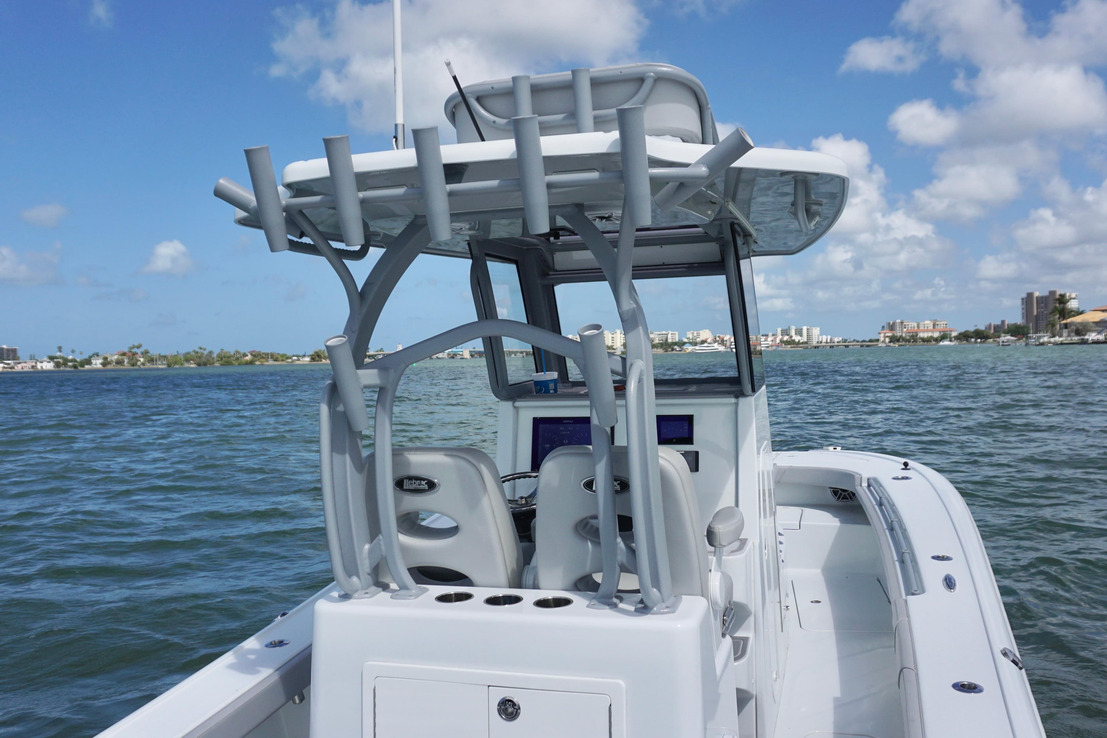 2024 Costa Custom Boats 264HC on water, showcasing helm and seating under clear blue sky.