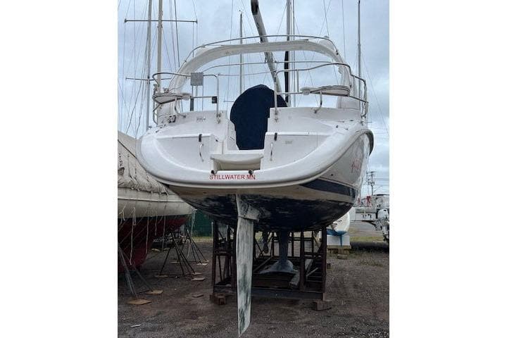 1999 Hunter 380 sailboat on dry dock, rear view, with visible keel and rudder.