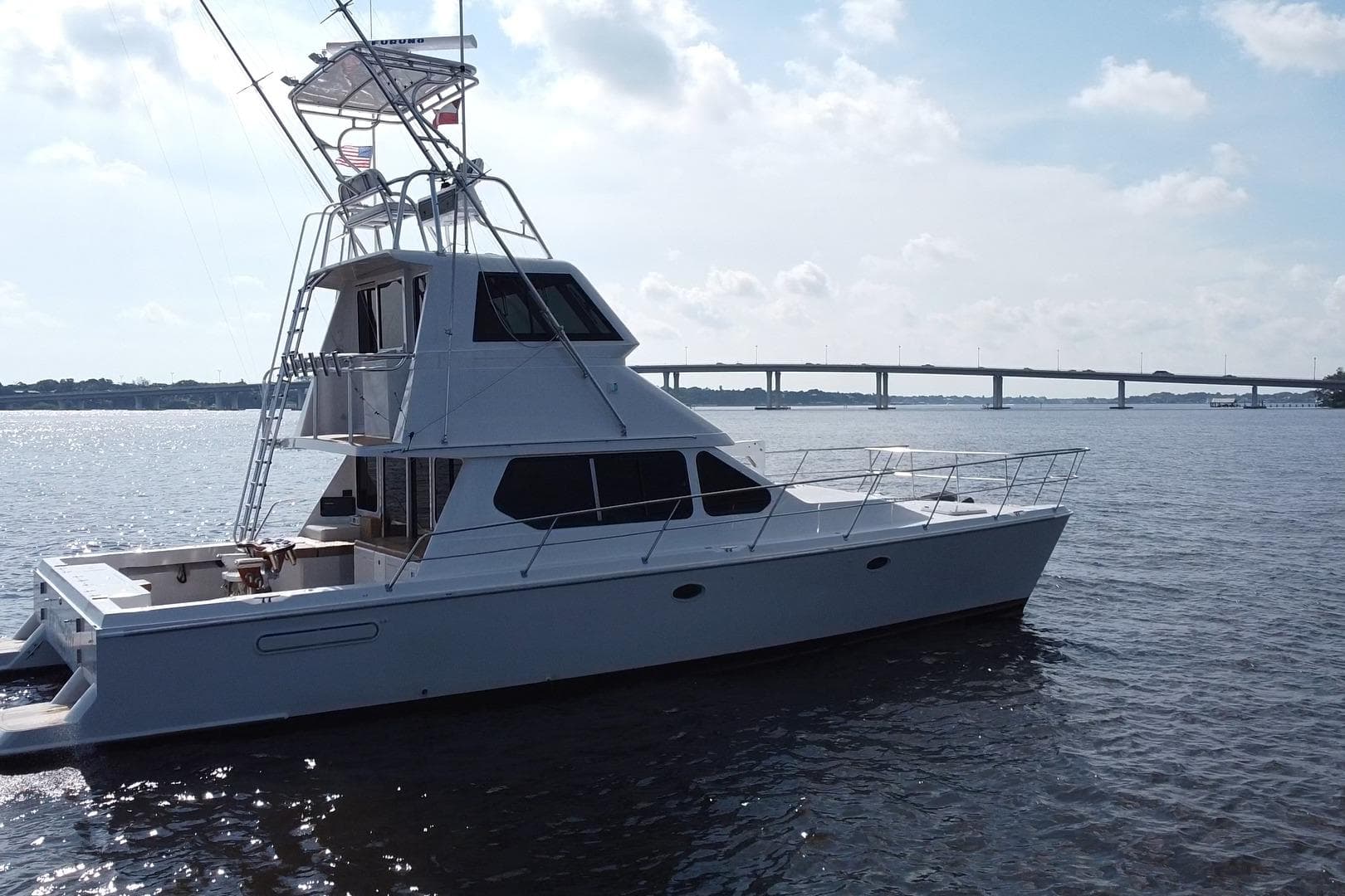 Voyager 44 yacht from 2000 on a calm river with a bridge in the background.