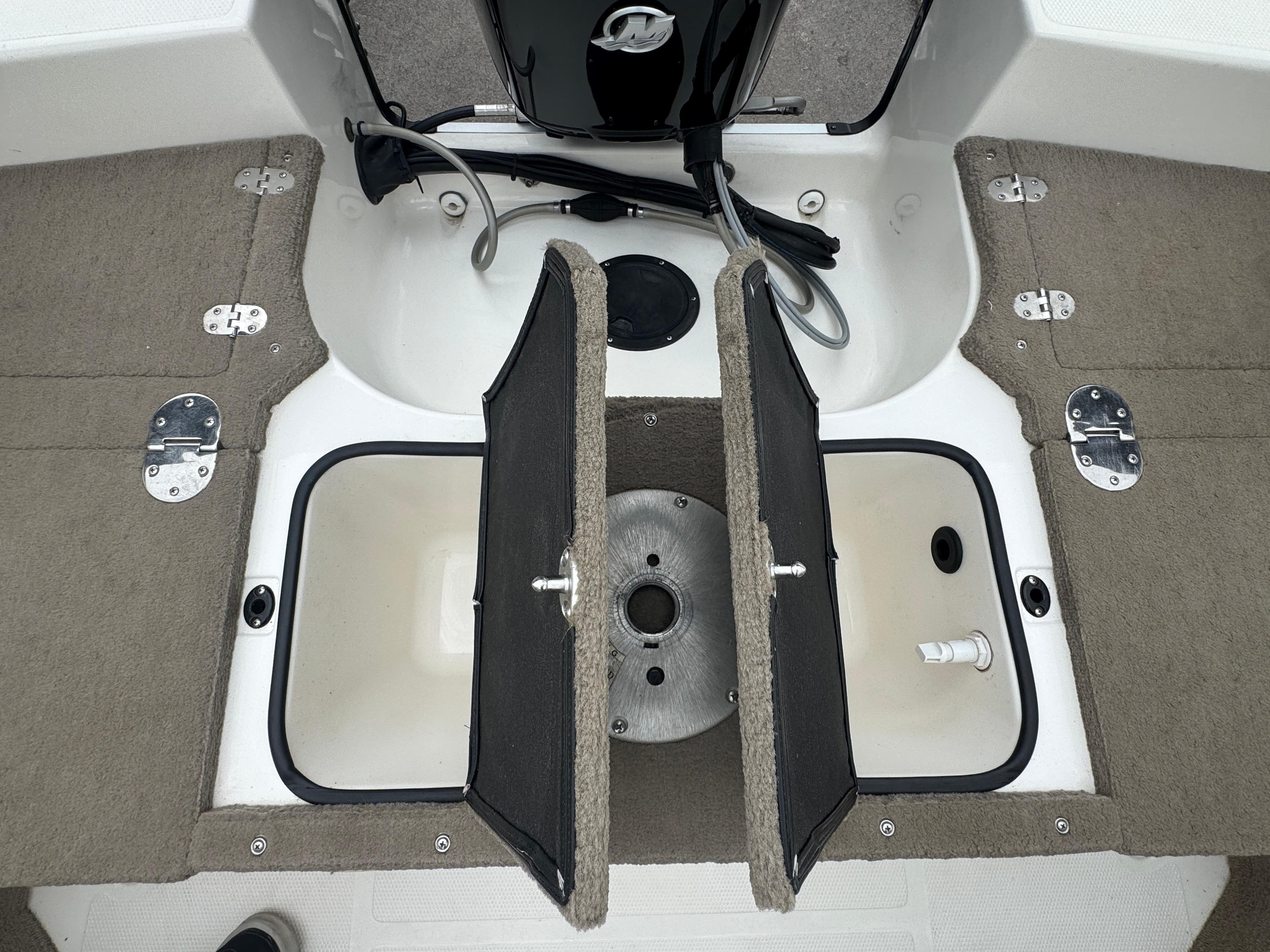 FinCraft 1850 boat interior storage compartments, 2011 model, featuring carpeted lids and metal hinges.