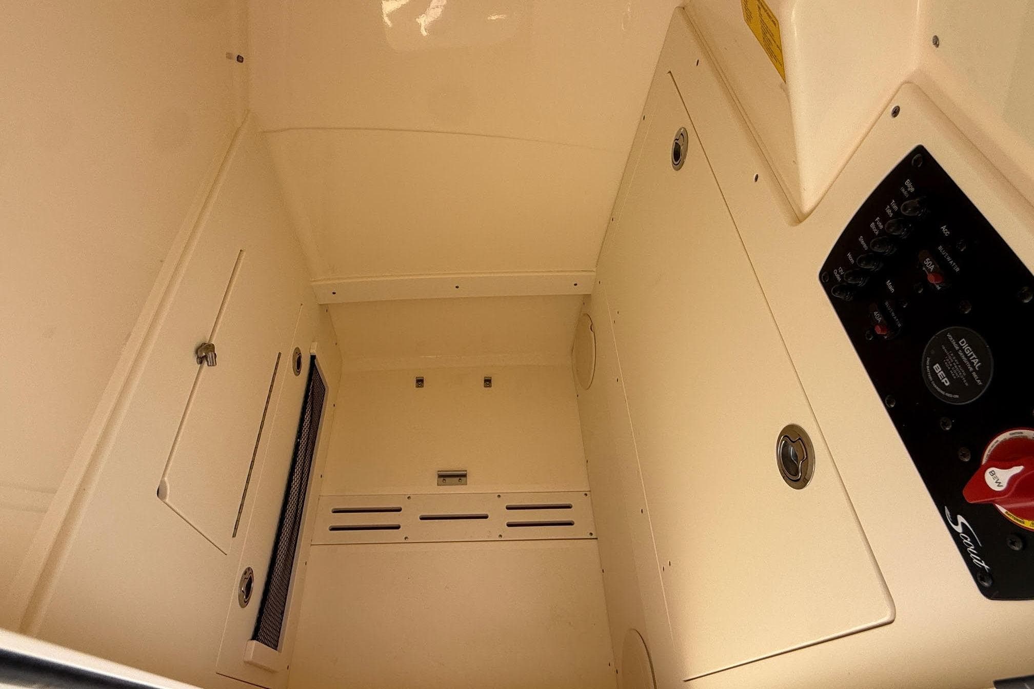 Interior view of 2026 Scout 220 XSF boat cabin with control panel and storage compartments.