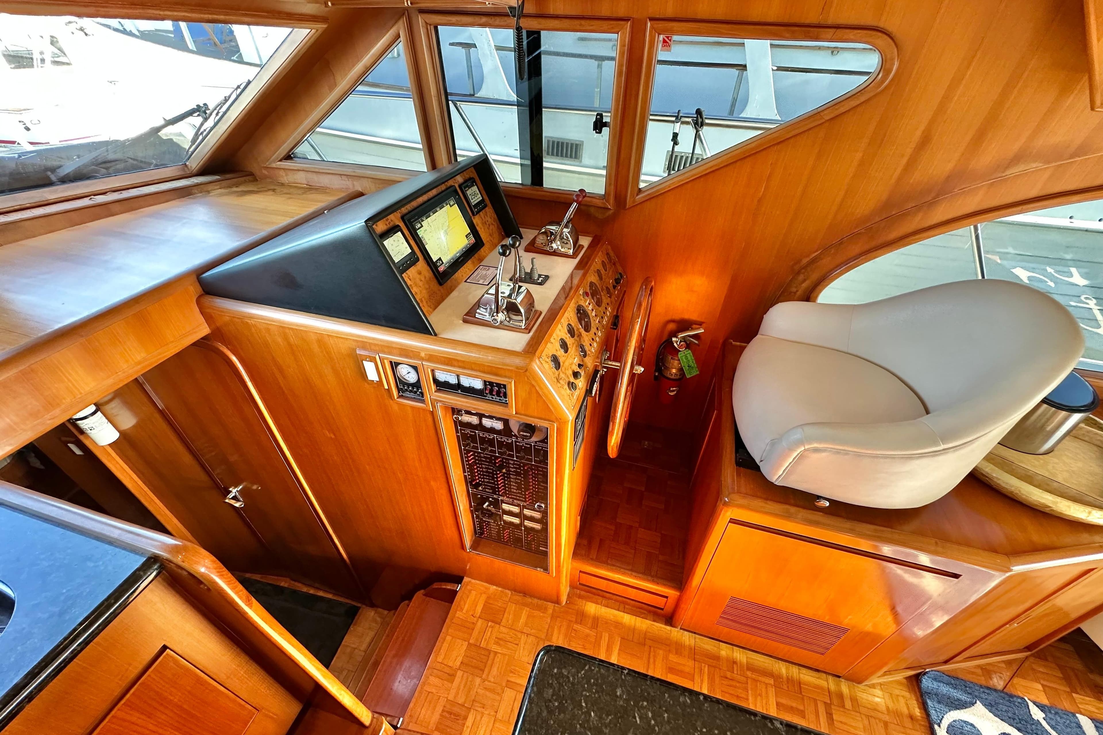 Interior helm of 2003 Ocean Alexander 42 Sport Sedan with wood finish and navigation controls.