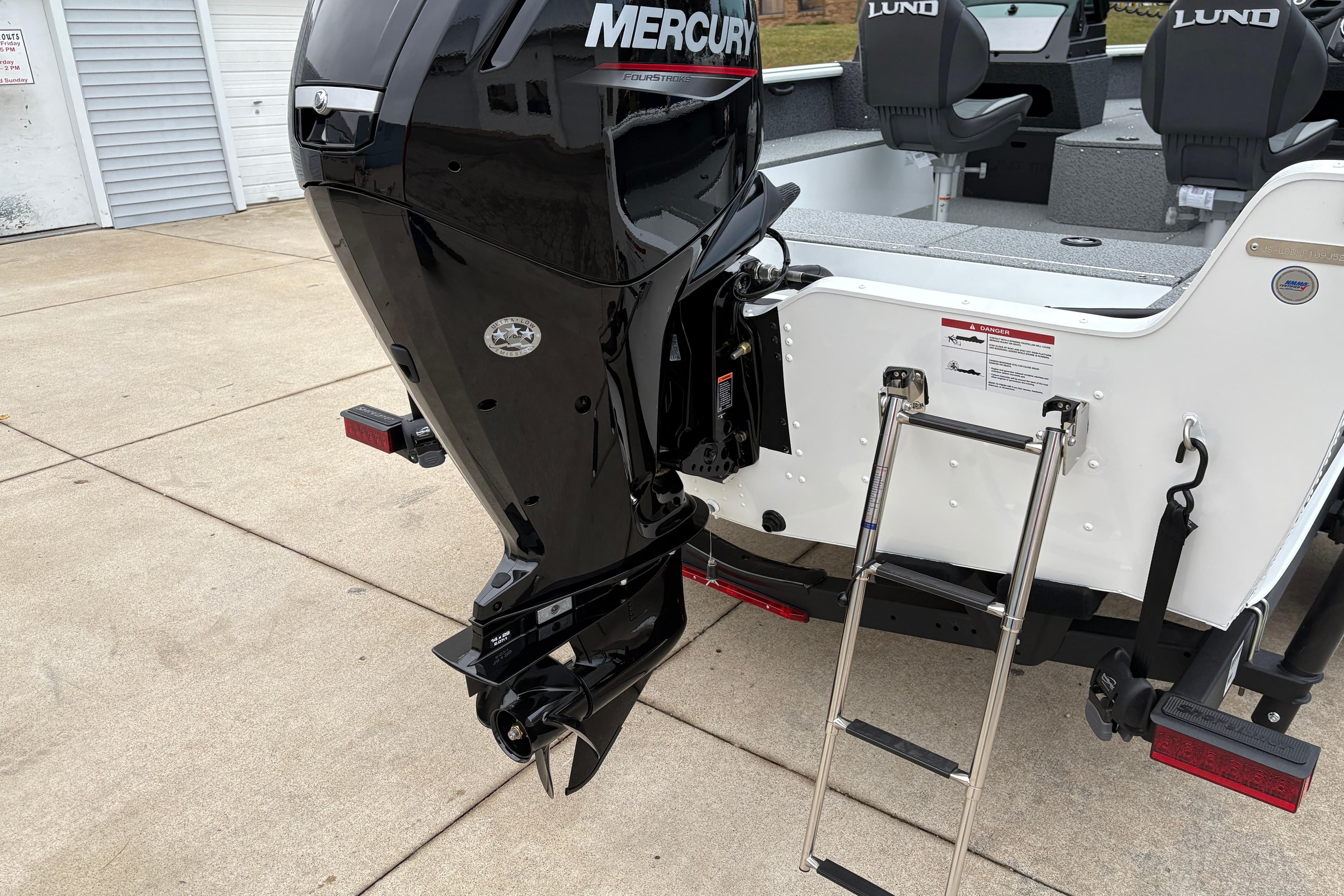 2026 Lund 1800 Explorer Sport boat with Mercury outboard motor and boarding ladder.