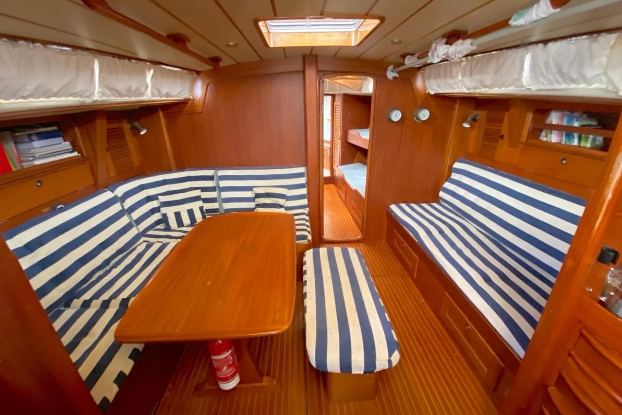 Interior of 1992 Hallberg-Rassy 45 yacht with striped seating and wooden finishes.