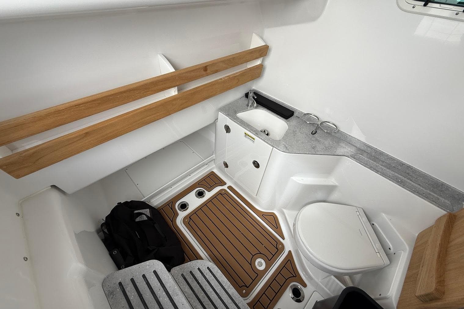 Interior of 2026 Everglades 315 Center Console boat with sink and toilet.