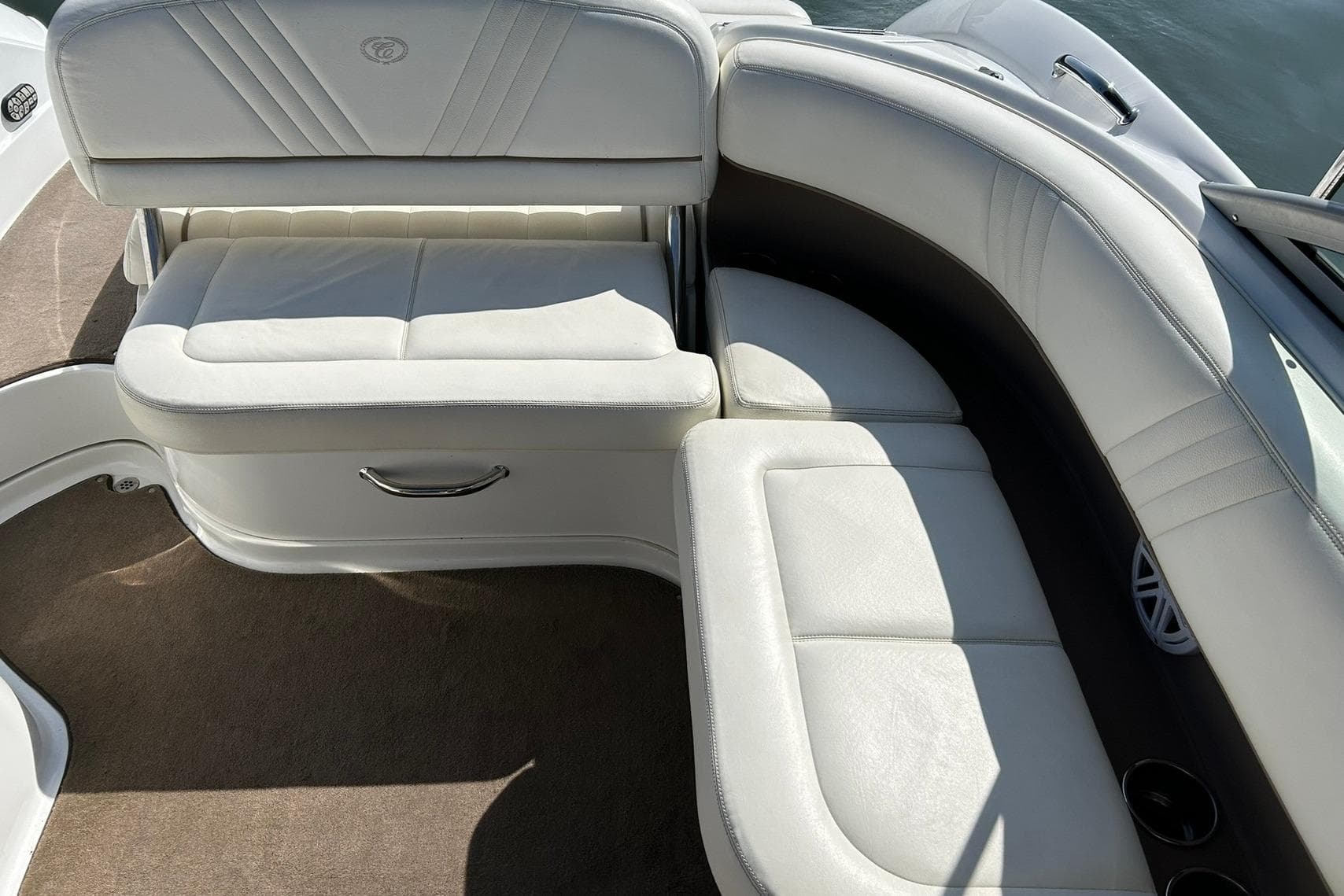 2007 Cobalt 232 boat interior with white leather seating and carpeted flooring.