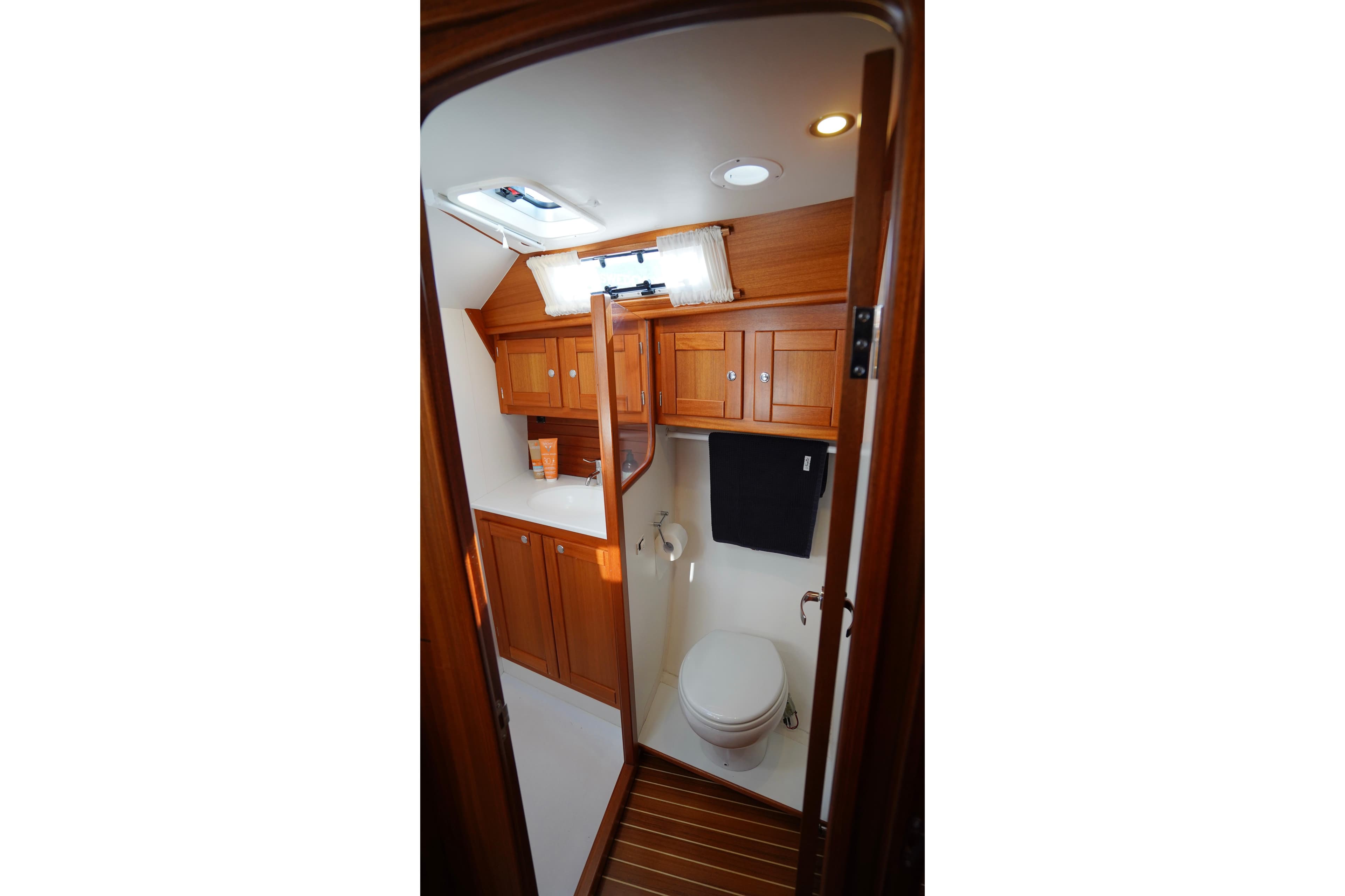 2016 Nordship 380 DS yacht bathroom with wooden cabinets and modern fixtures.