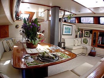 Luxurious 1990 Cutter TDM Center Cockpit interior with elegant dining area and floral centerpiece.