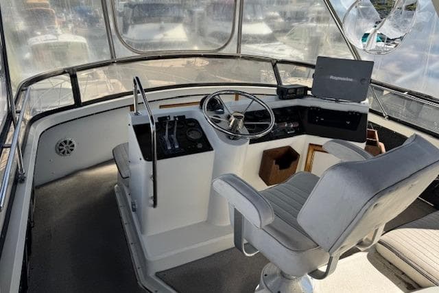 1986 Carver 4207 Aft Cabin Motor Yacht helm with steering wheel and navigation equipment.