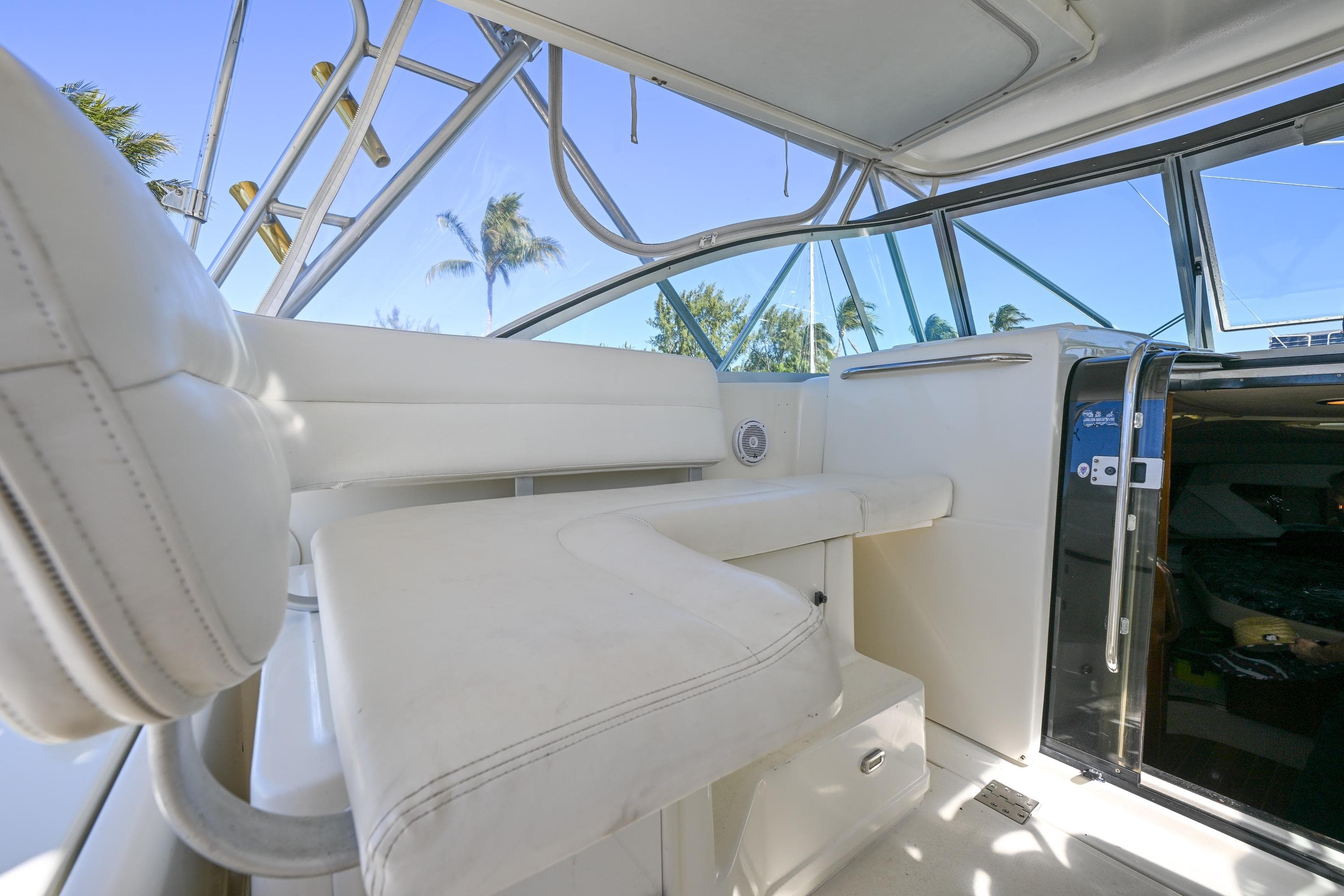 Interior of 2000 Pursuit 3400 Express boat with white seating and open cabin door.