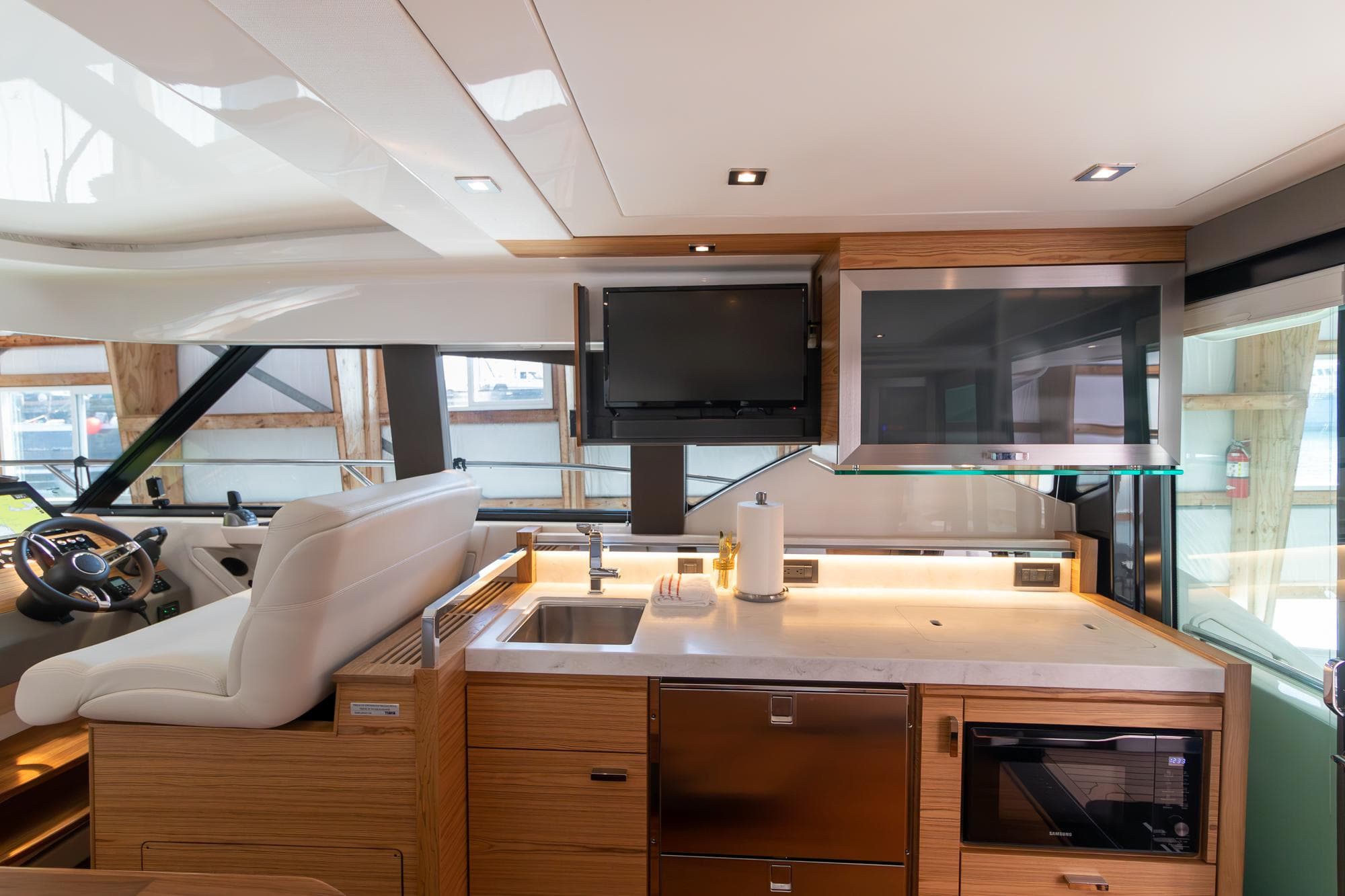 Luxurious interior of 2023 Tiara Yachts C44 Coupe with modern kitchen and helm station.