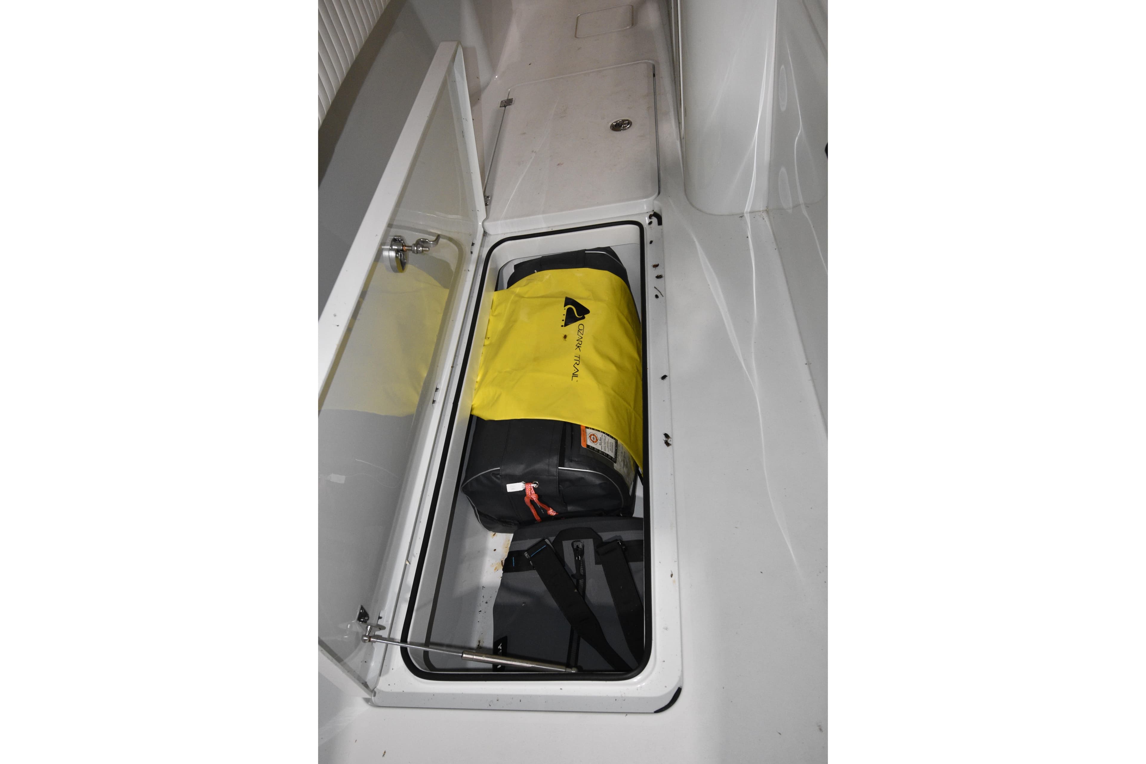 Open storage compartment on 2016 Freeman 37VH boat with yellow bag inside.