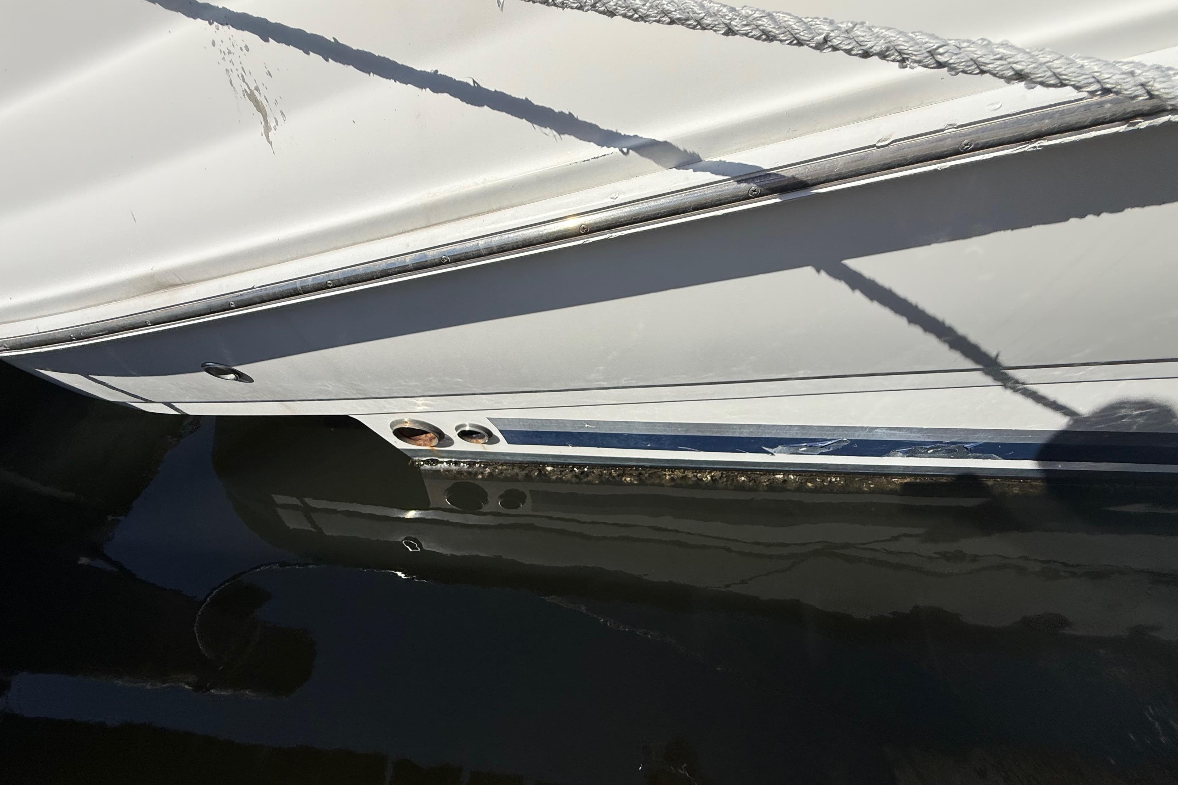 2008 Sea Ray 38 Sundancer boat hull with visible waterline and docked ropes.