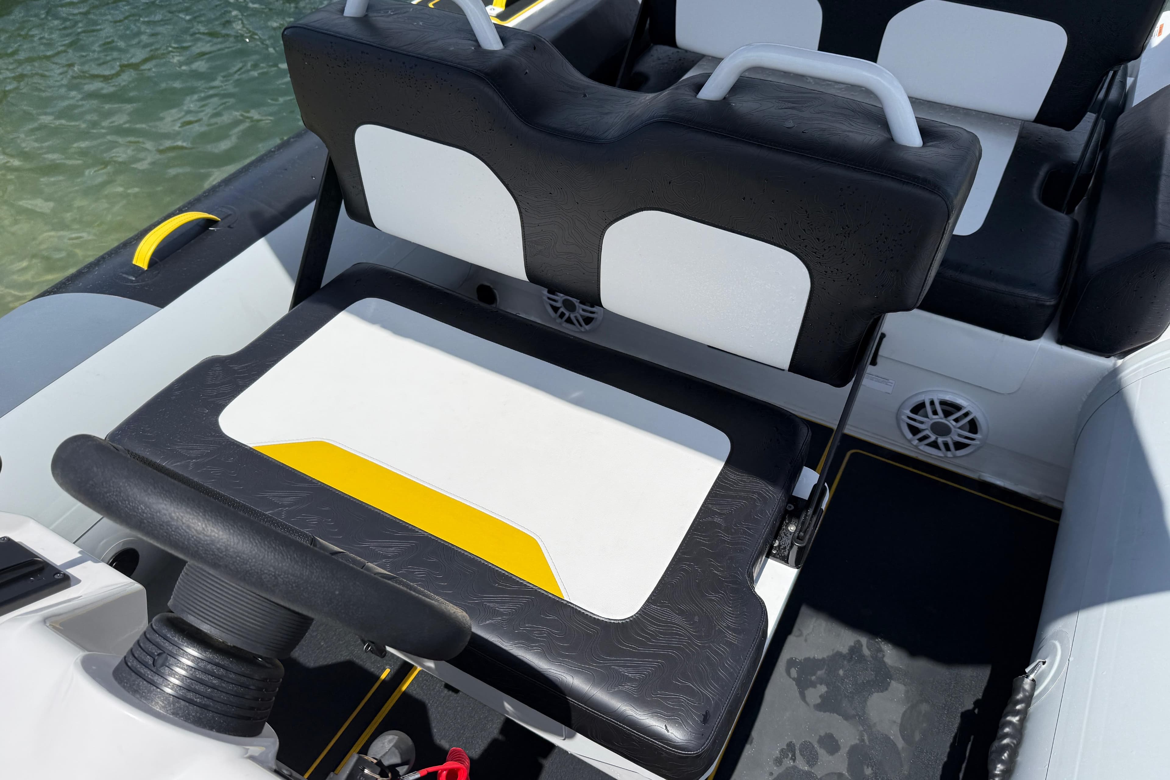 2026 Highfield Velox 560 boat interior with black and white seating, yellow accents.
