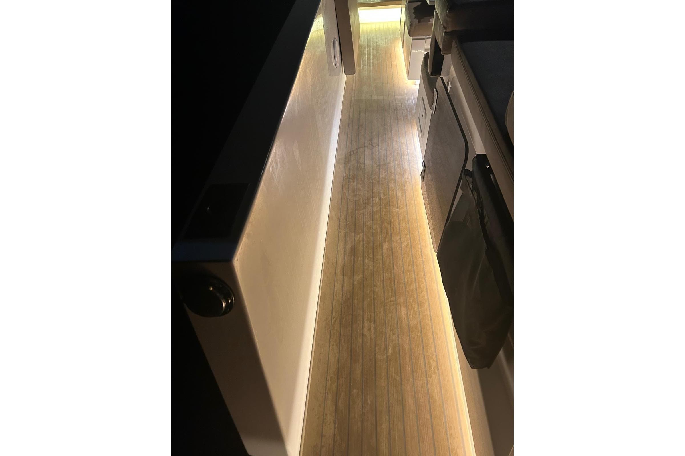 Interior view of 2018 De Antonio Yachts D33, featuring illuminated wooden flooring.