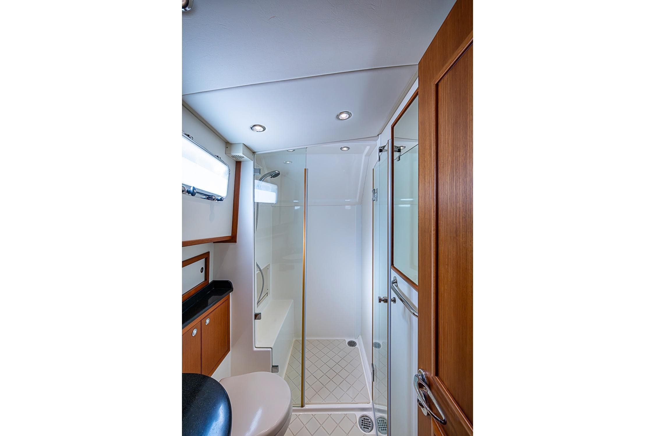 Luxurious bathroom in 2013 Grand Banks 43 Europa yacht with modern shower and wooden accents.