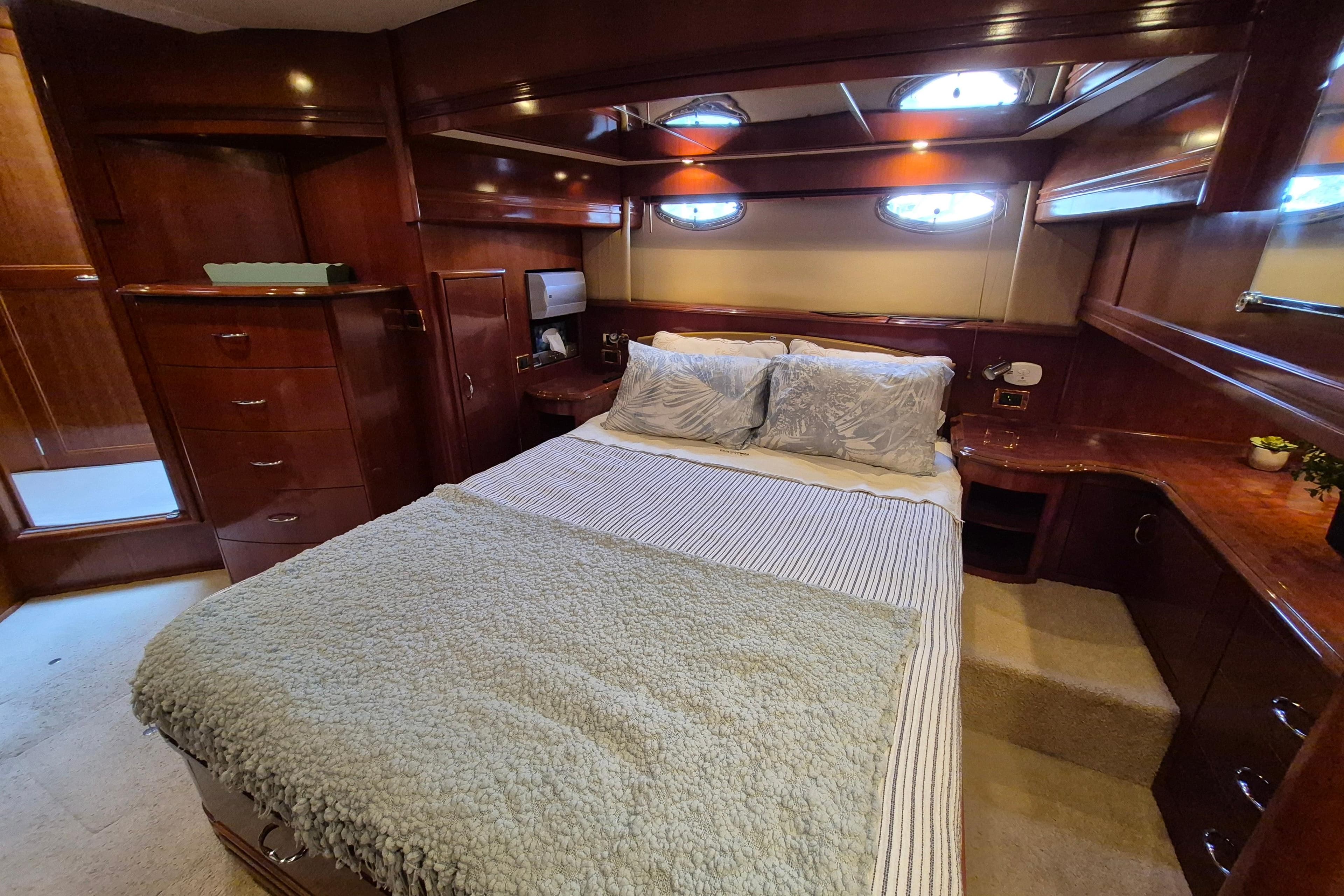 Luxurious 2005 Carver 560 Voyager bedroom with elegant wood finish and cozy bedding.
