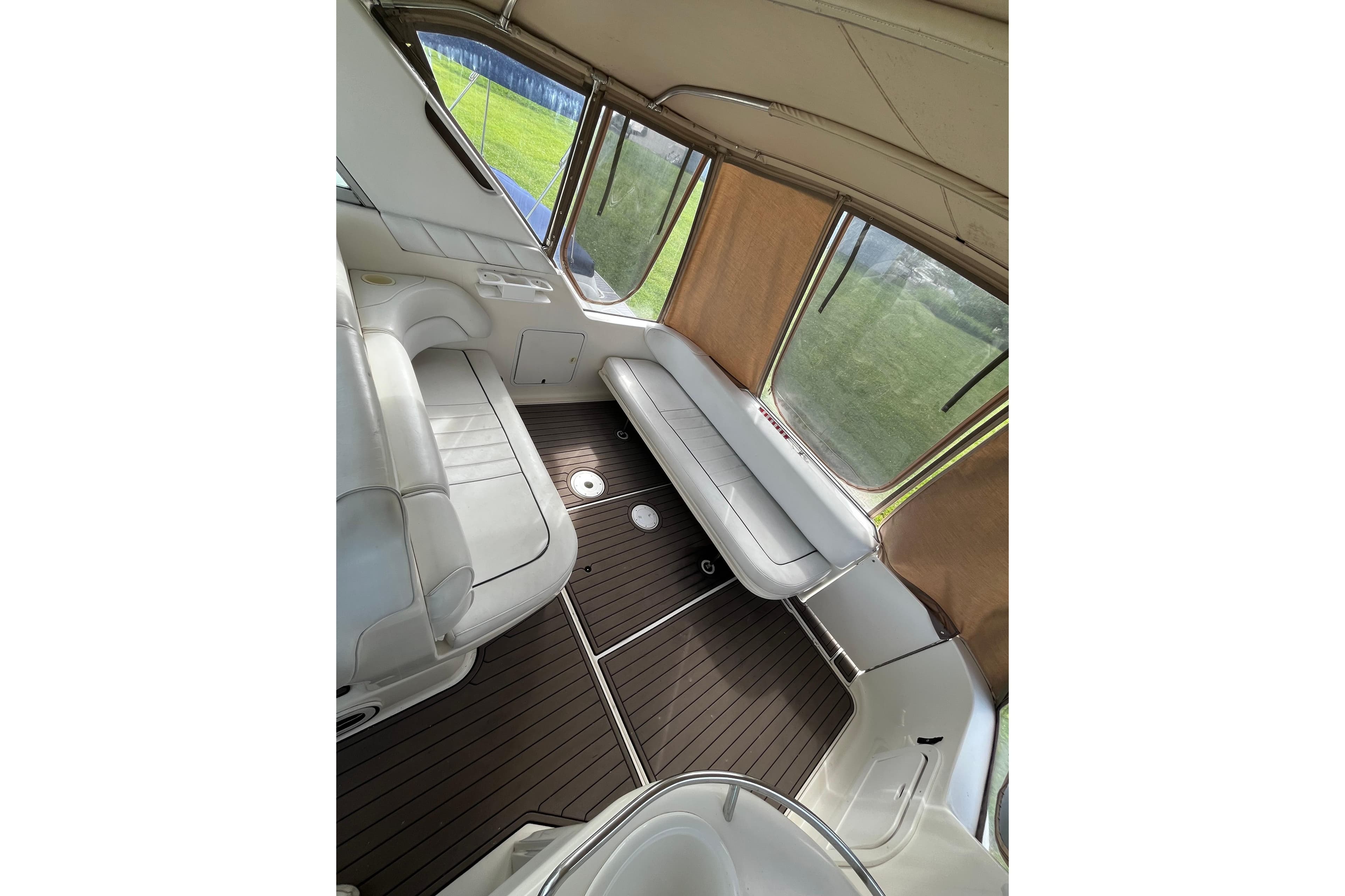 Interior of 1995 Sea Ray Sundancer 330 with white seating and wood flooring.