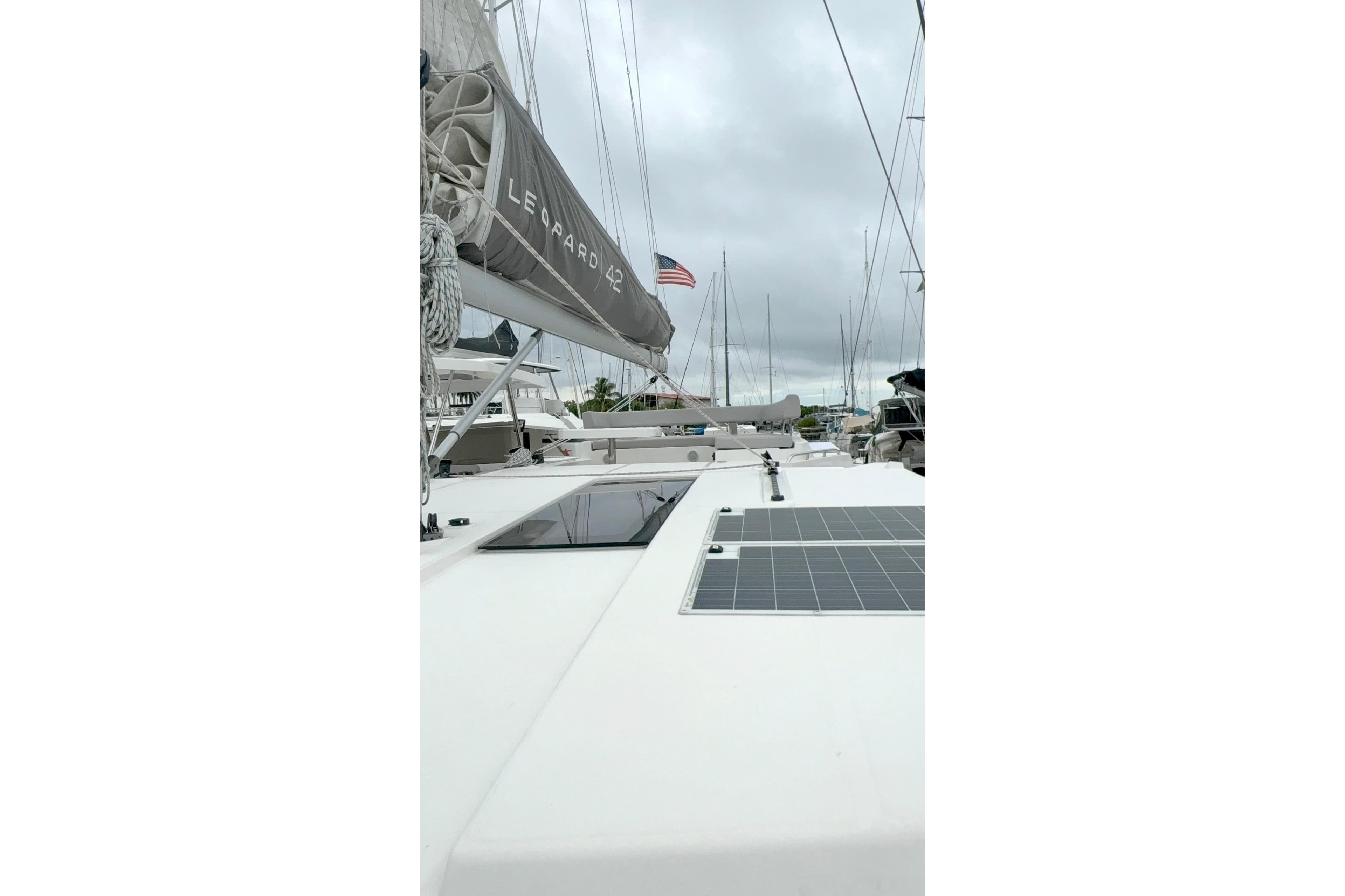 Sailing yacht Leopard 42, 2025 model, docked with solar panels and American flag.