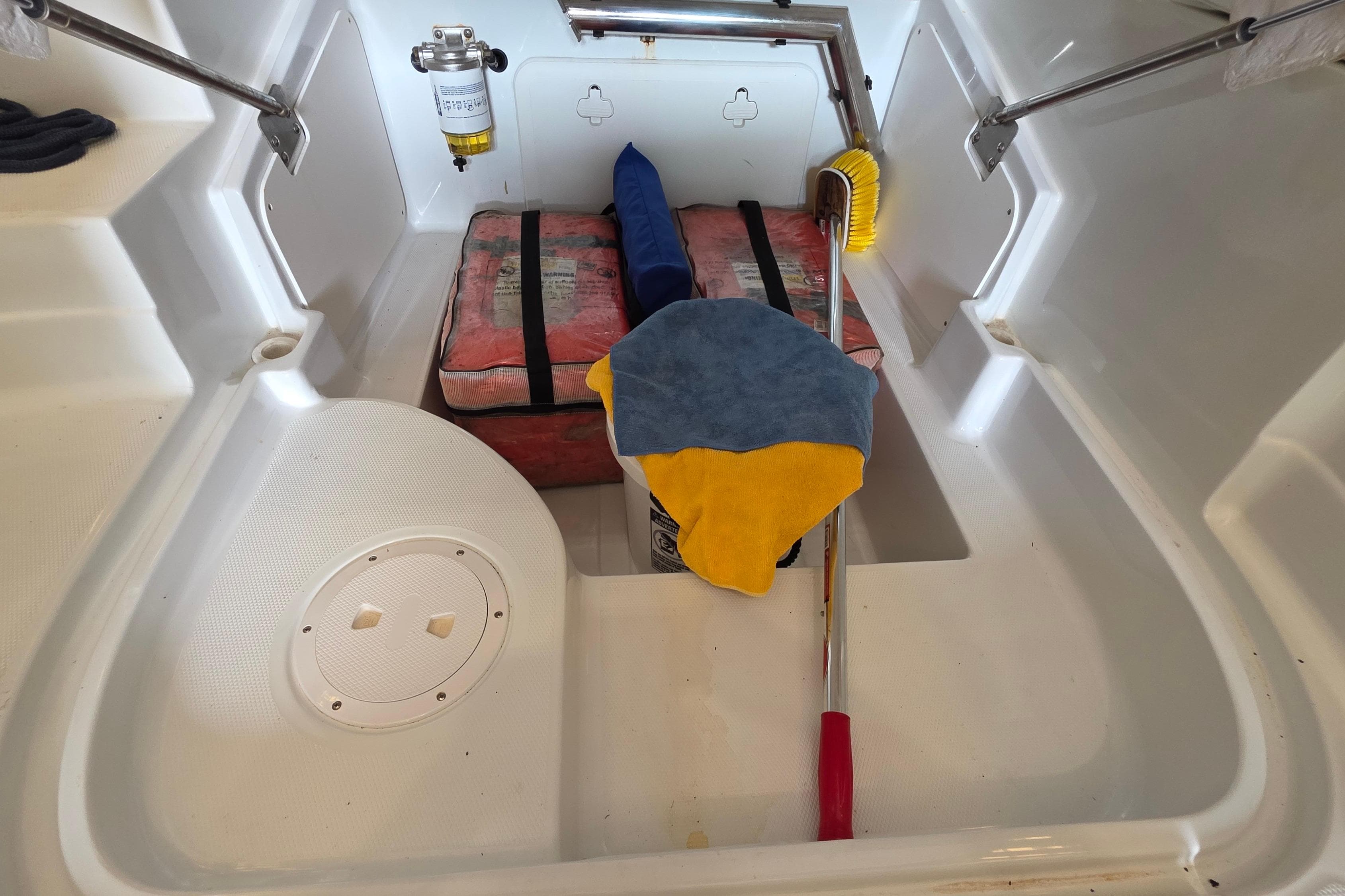 Storage compartment of a 2012 SouthWind 2400 SD boat with cleaning supplies and equipment.