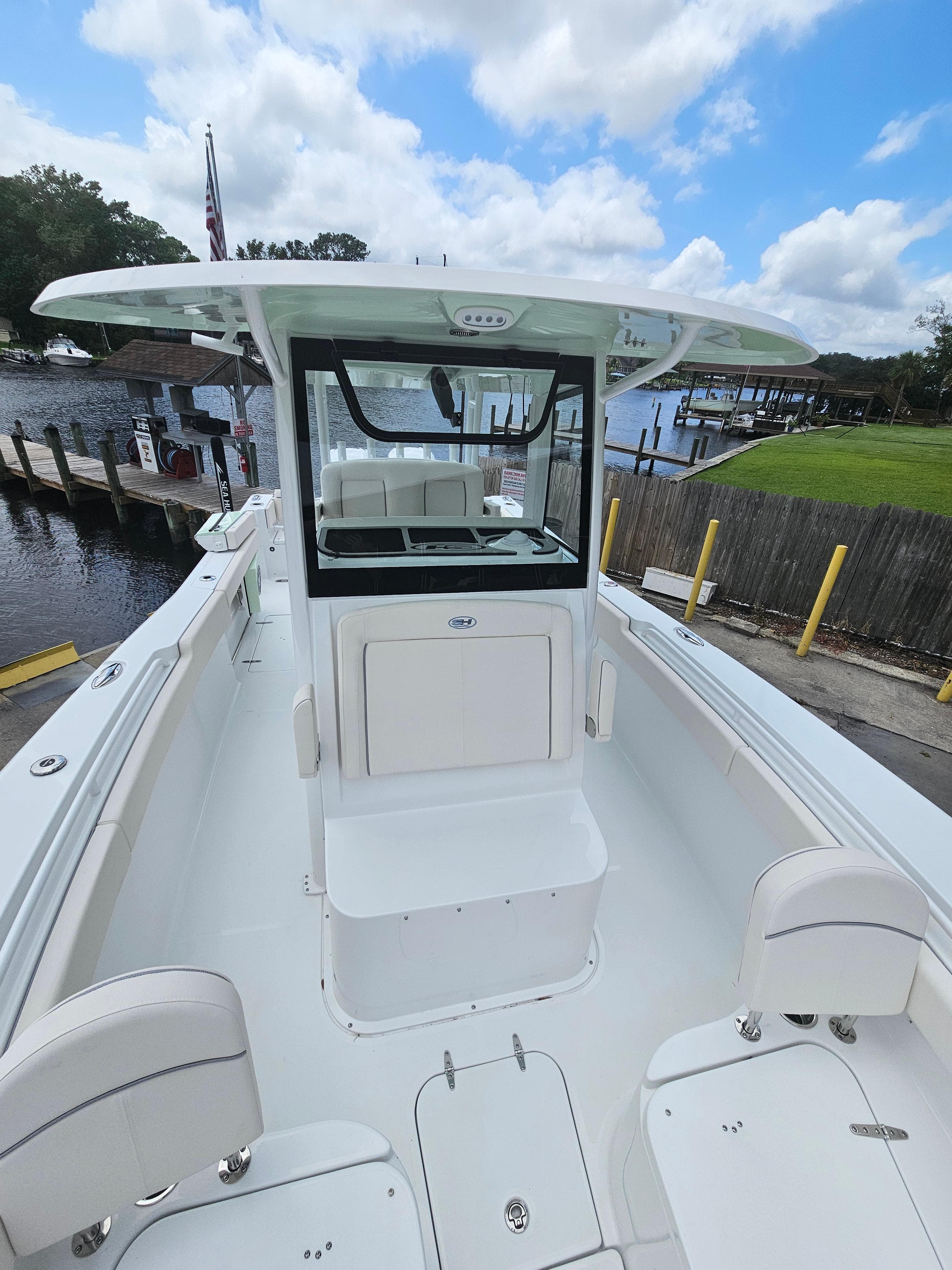 2025 Sea Hunt Gamefish 28 FS boat docked by a scenic waterfront.