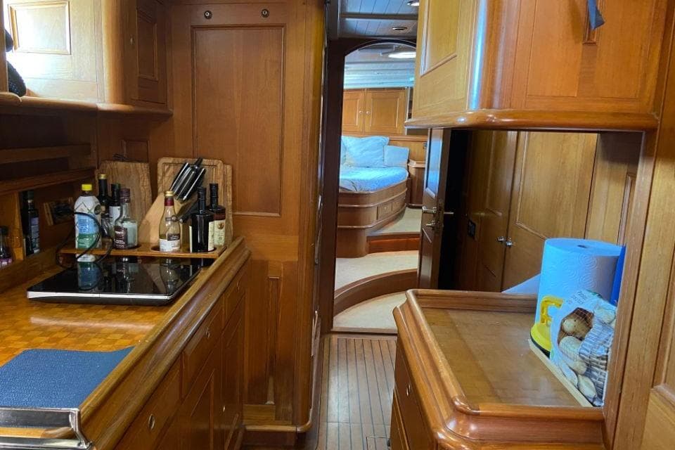 Luxurious wooden interior of 2002 Holland Jachtbouw Classic Hoek 82 yacht kitchen and bedroom.