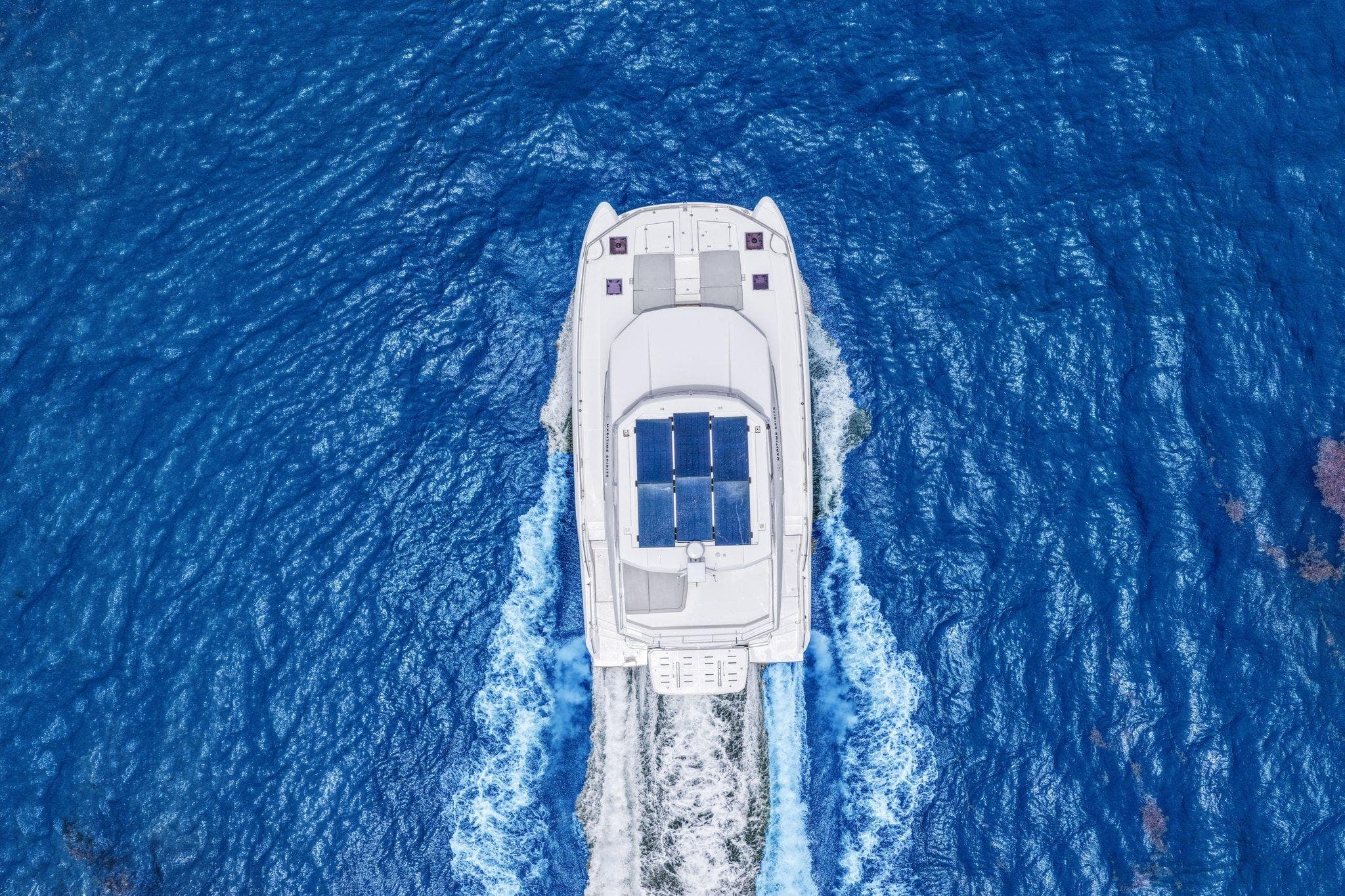 Aerial view of 2025 Leopard 53 Powercat cruising on vibrant blue ocean waters.