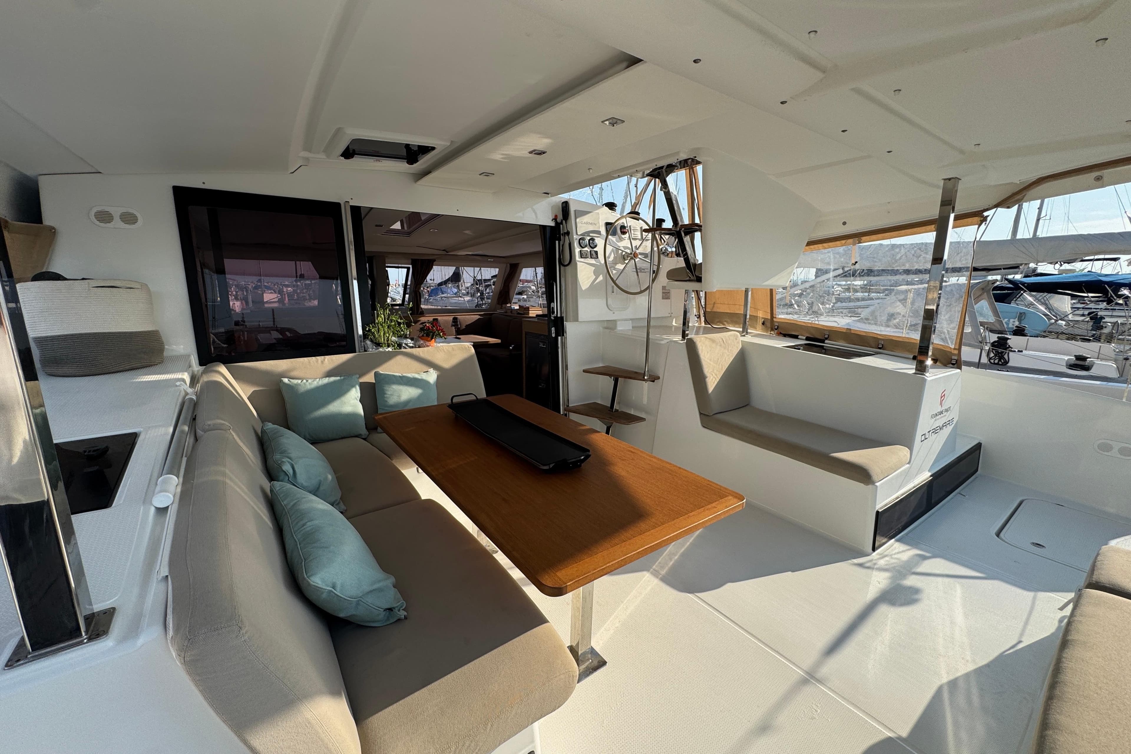 2024 Fountaine Pajot Isla 40 catamaran interior with seating, table, and helm station.