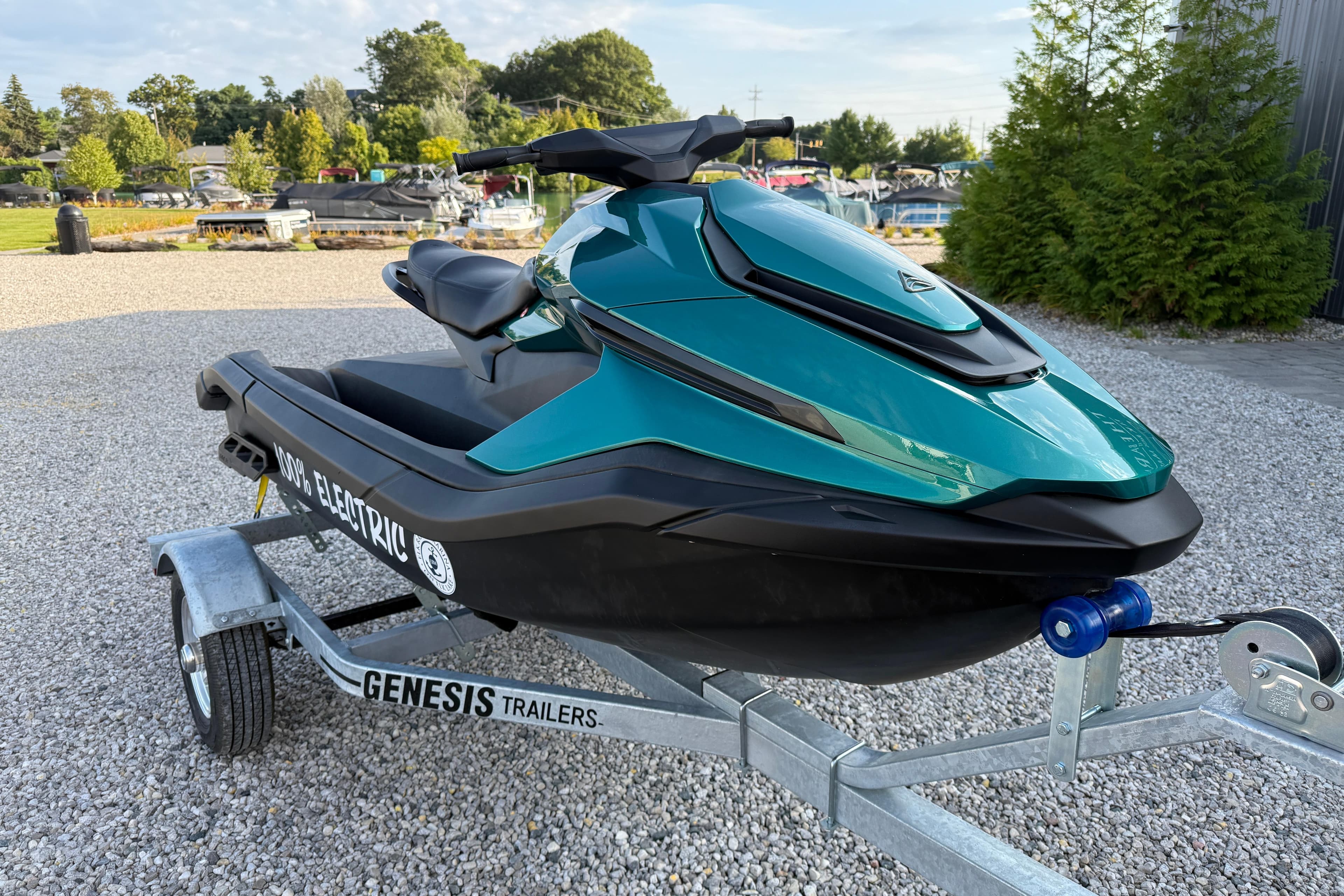 2024 Taiga Orca electric jet ski on Genesis trailer, parked on gravel.
