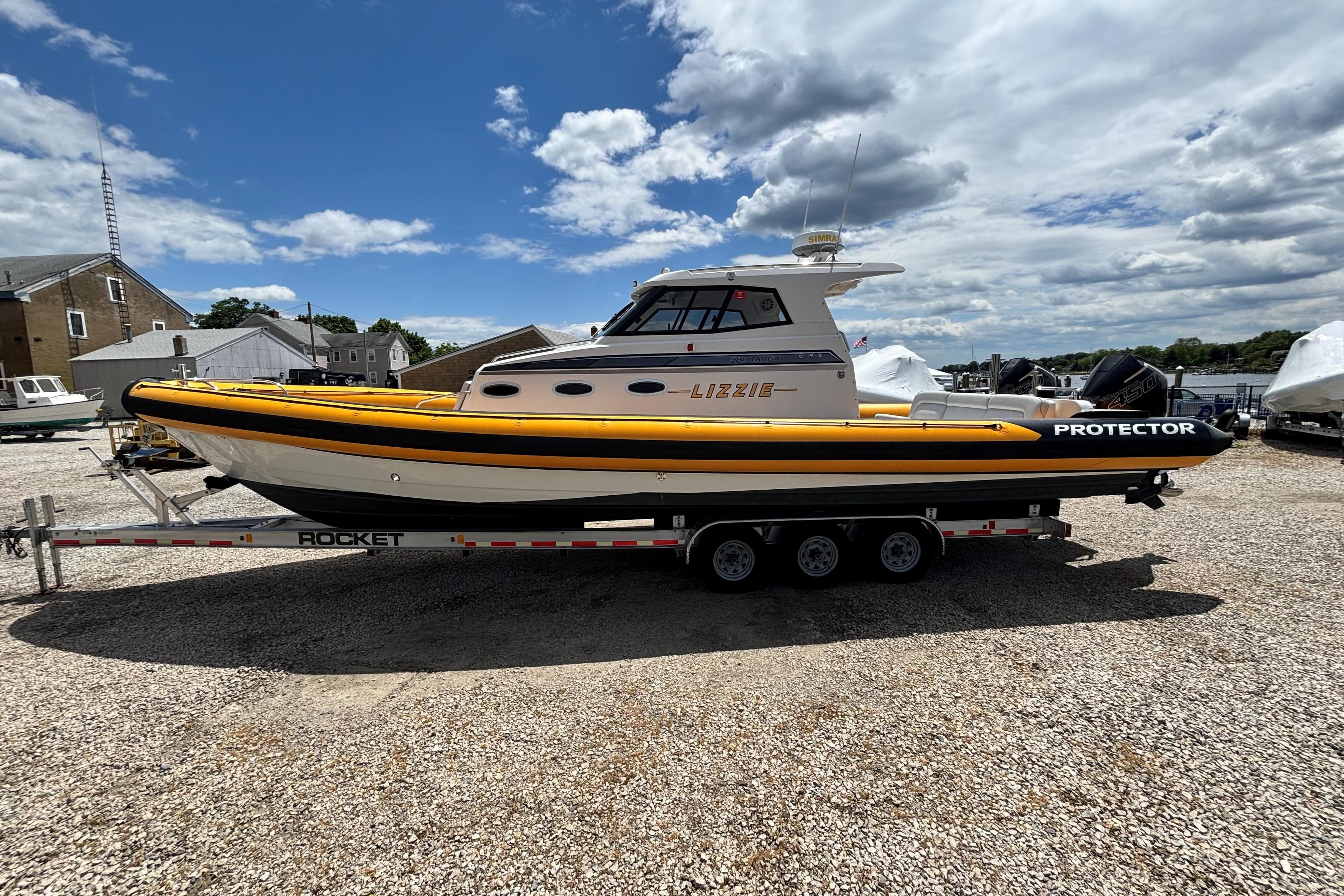 2020 Protector 380 Targa boat on trailer, parked outdoors under a partly cloudy sky.