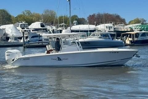 A 2023 Jupiter 30 boat cruising in a marina with other boats docked nearby.