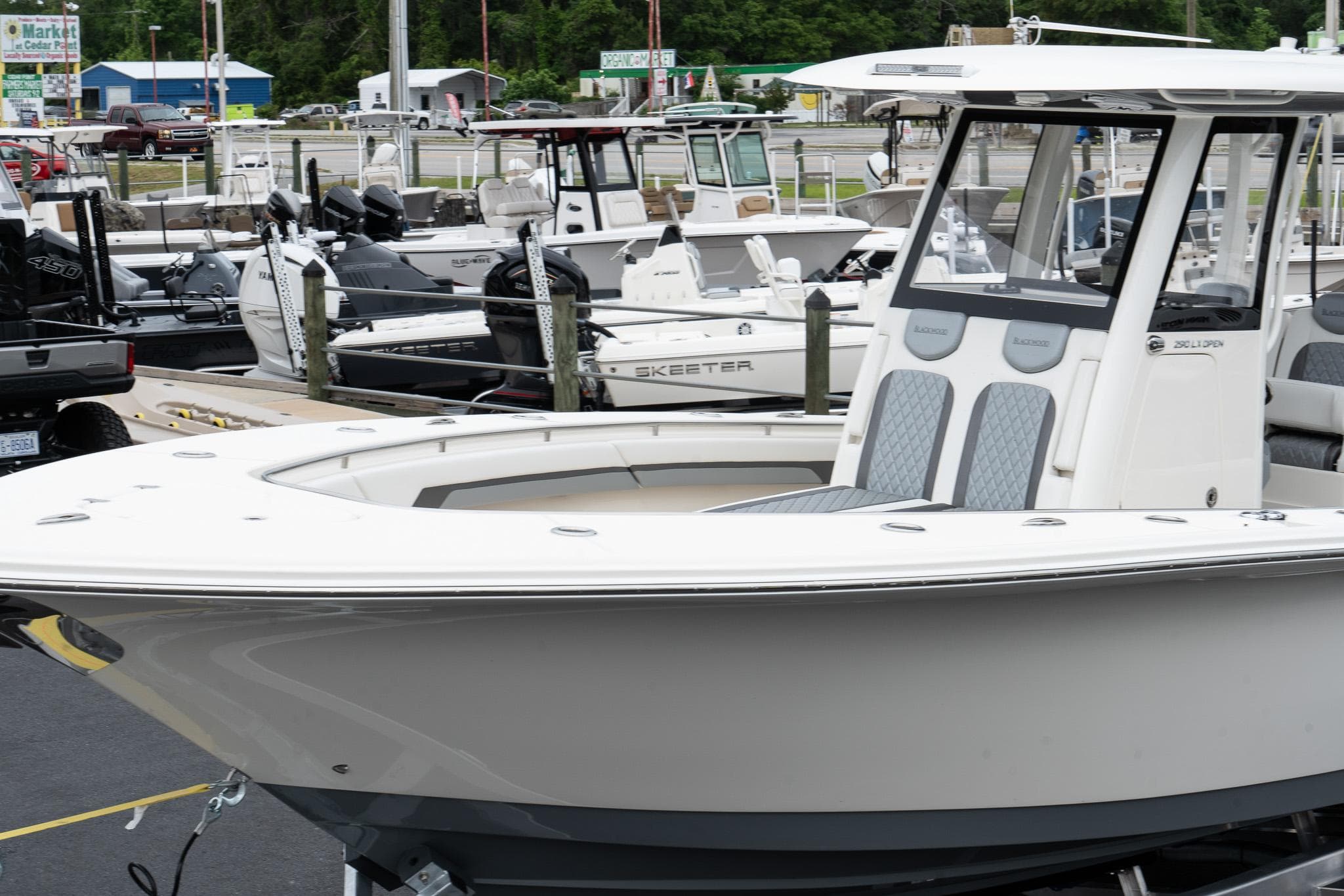 2025 Blackwood 290 OPEN boat displayed at a marina with other boats in the background.