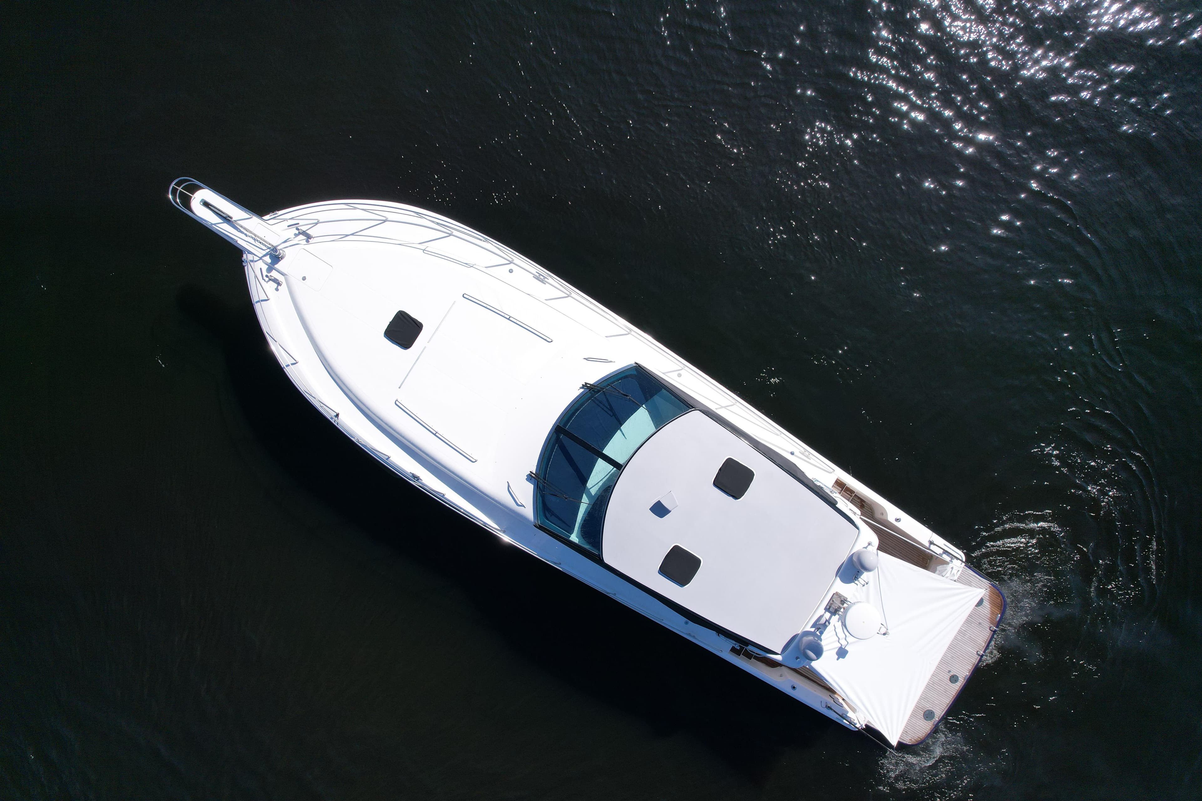 Aerial view of 1999 Uniesse 57 Open yacht on dark water.