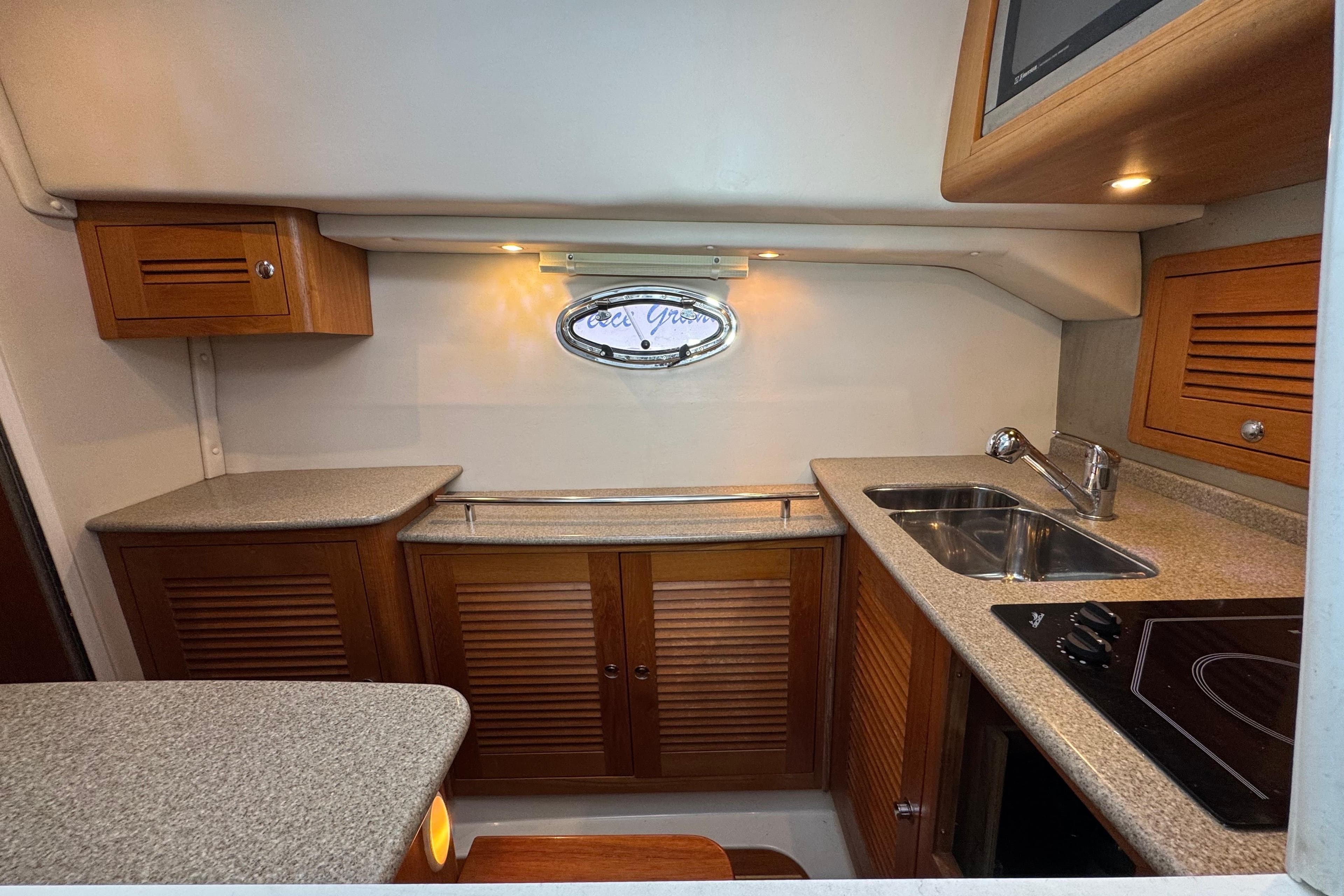 2006 Glacier Bay 3470 Ocean Runner boat kitchen with wooden cabinets and modern appliances.