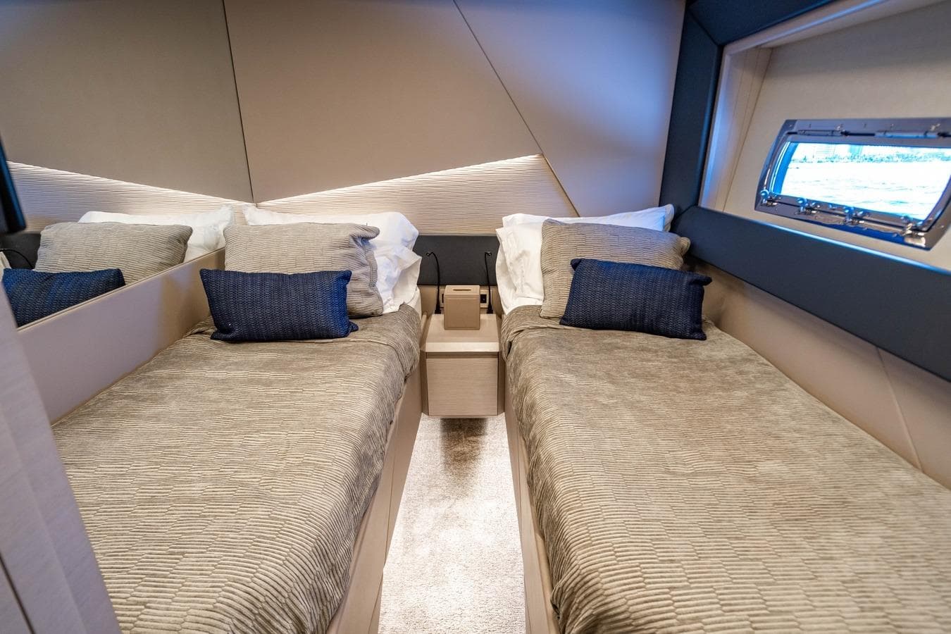 Luxurious twin cabin interior of 2023 Pershing 7X yacht with modern design and window view.