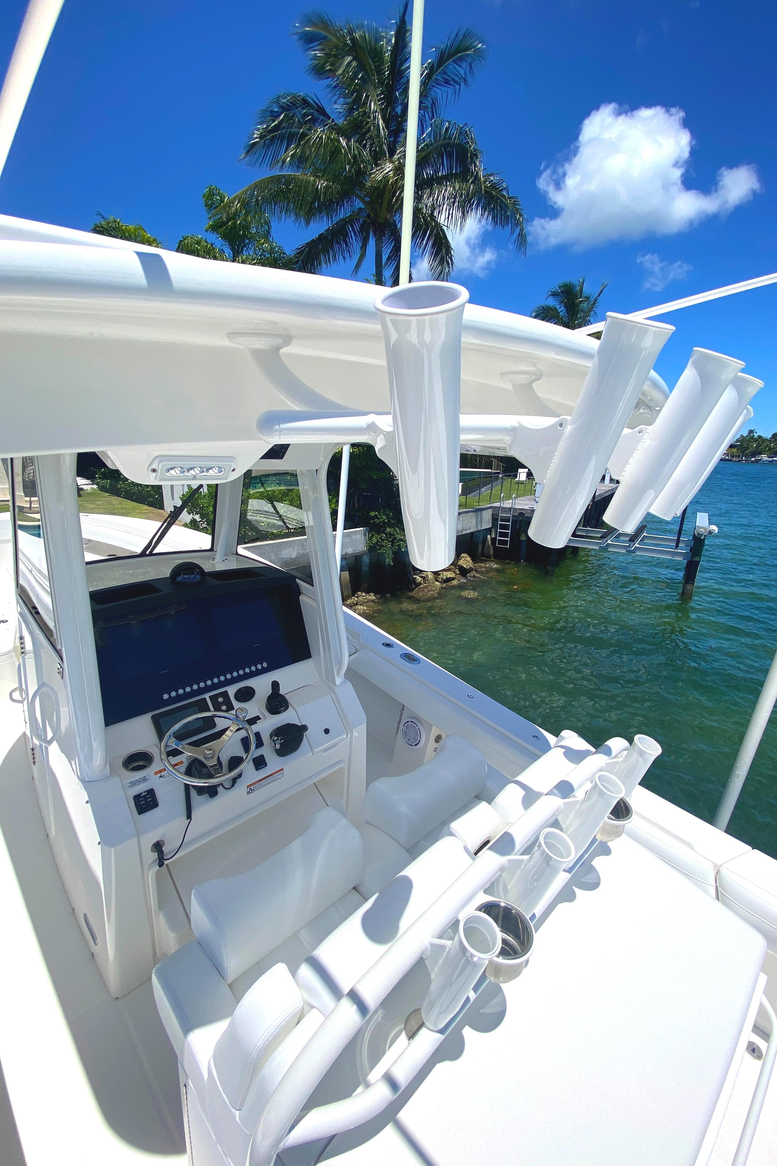 2020 Regulator 31 boat with advanced navigation system and rod holders, docked by tropical waters.