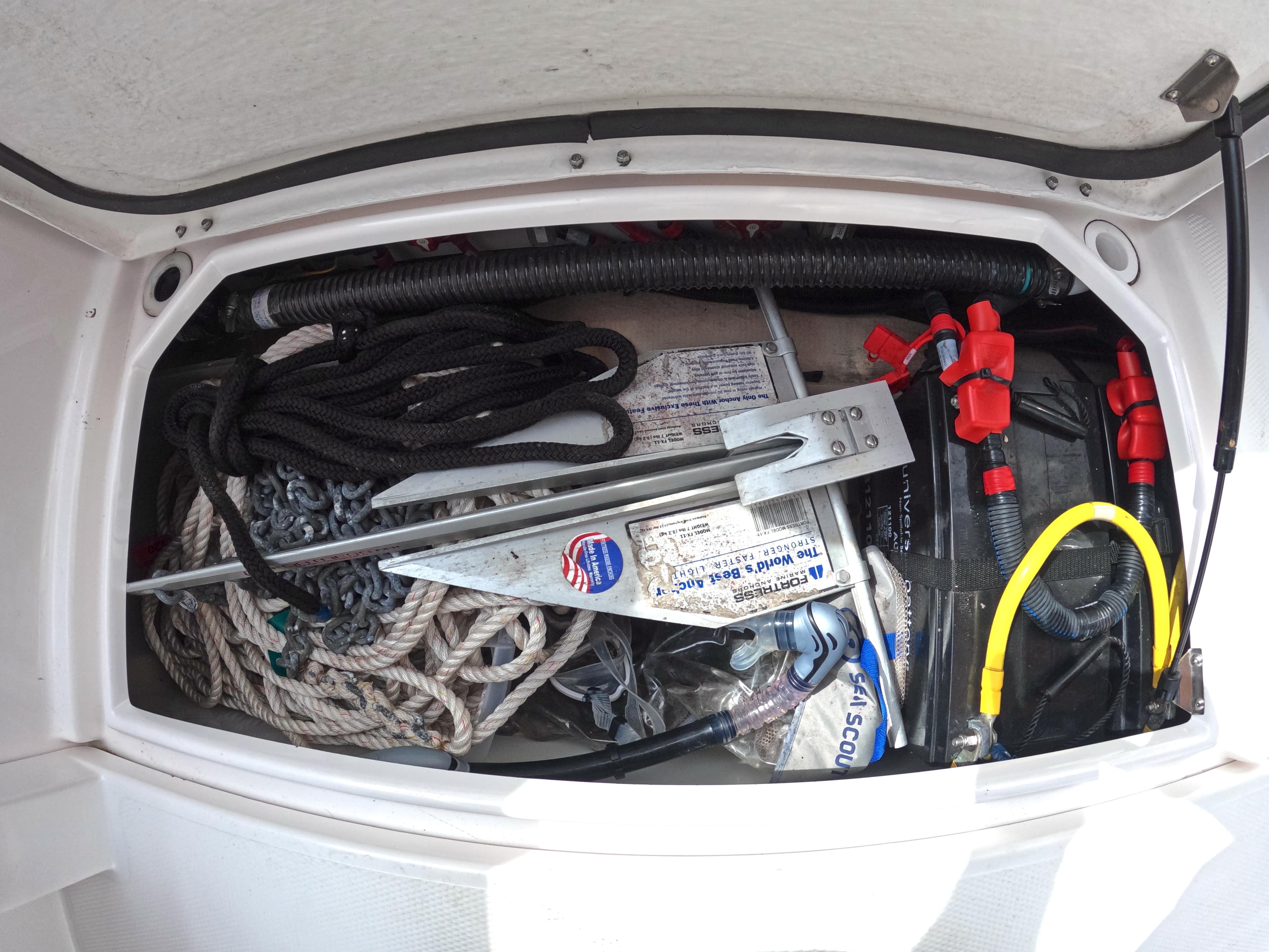 Storage compartment of 2020 Ranger Tugs R-27 with ropes, anchor, and equipment.