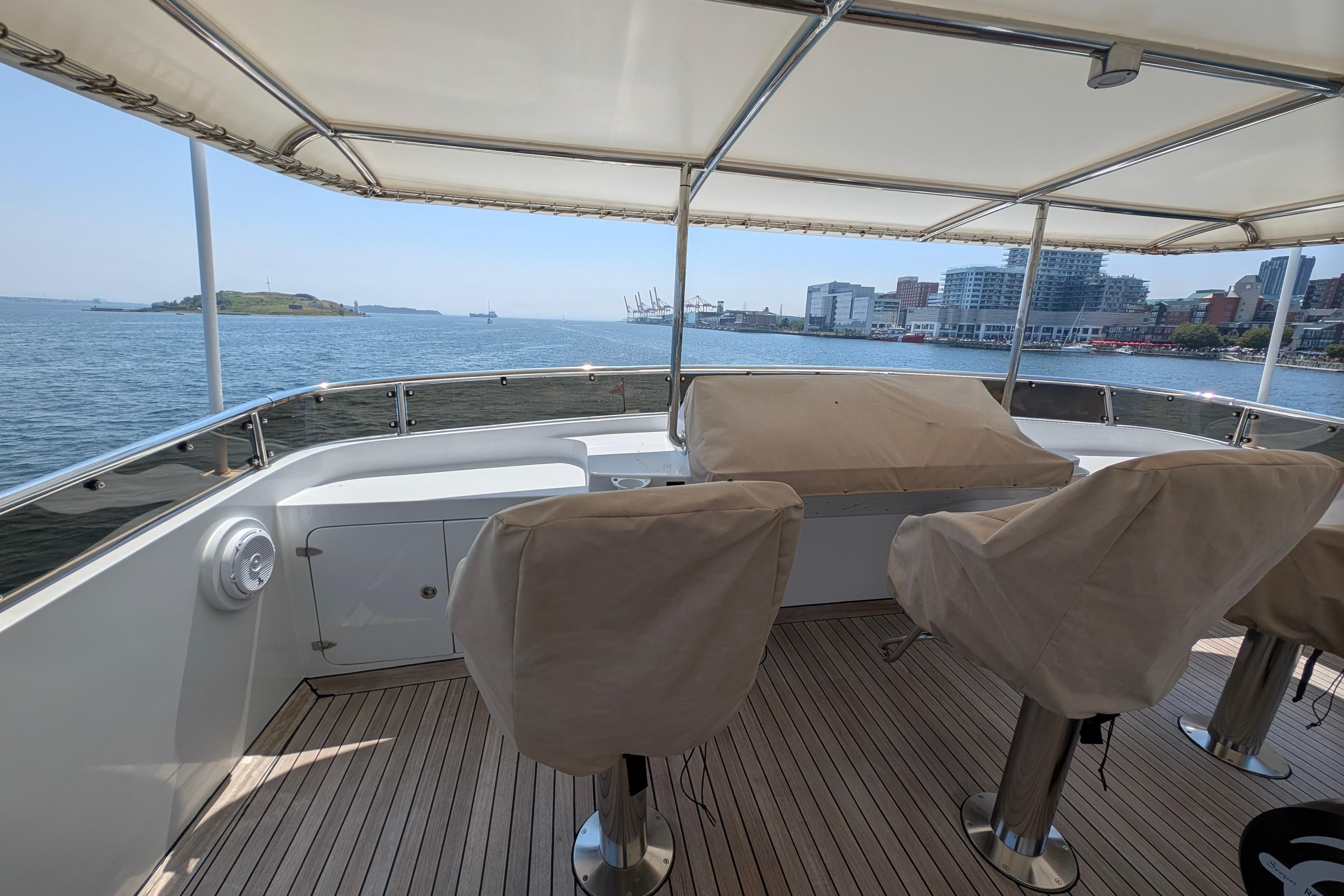 Luxurious 2001 Doggersbank yacht deck with covered seating, overlooking scenic waterfront views.