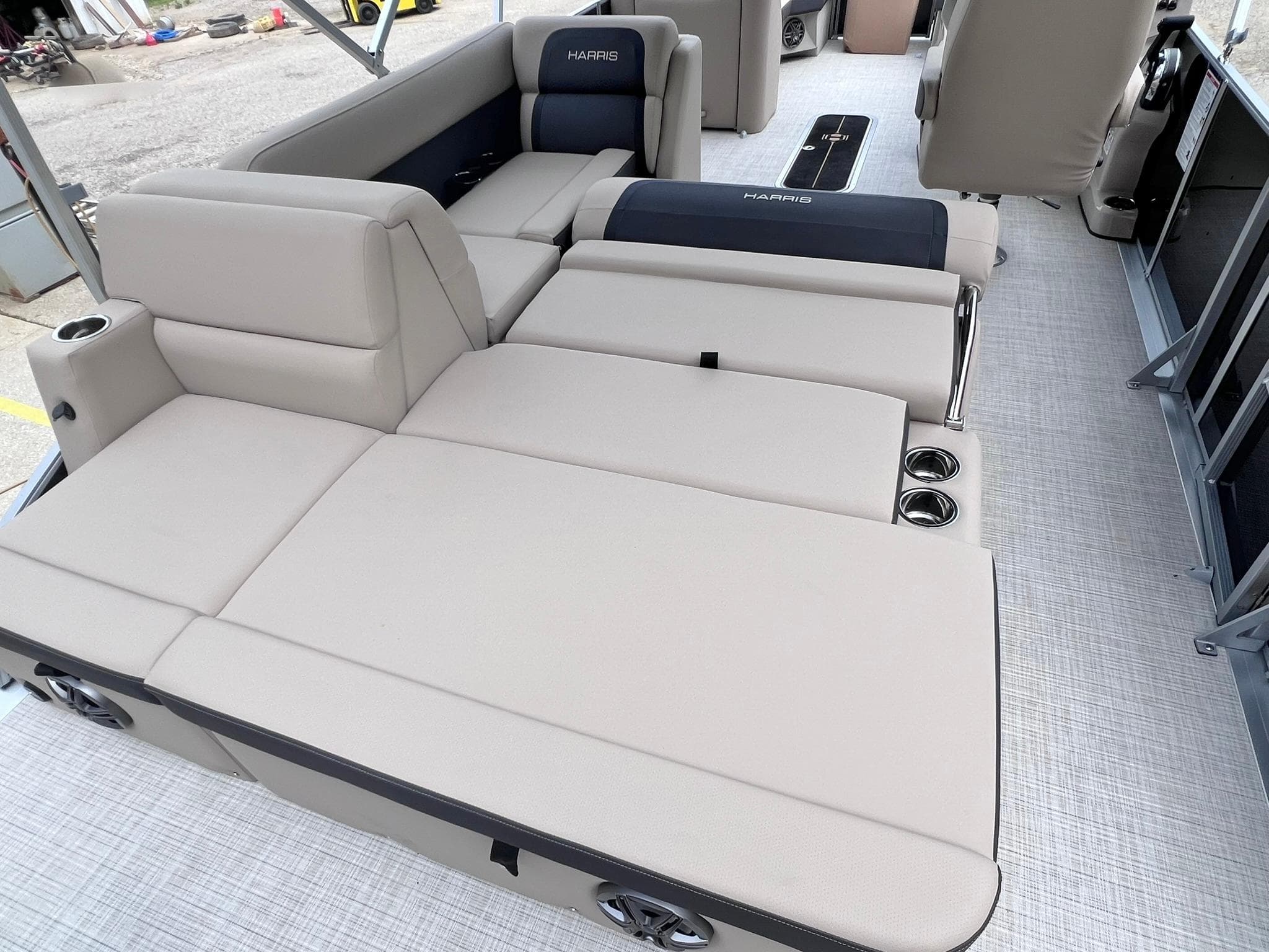 2025 Harris Cruiser 230 boat interior with beige seating and cup holders.