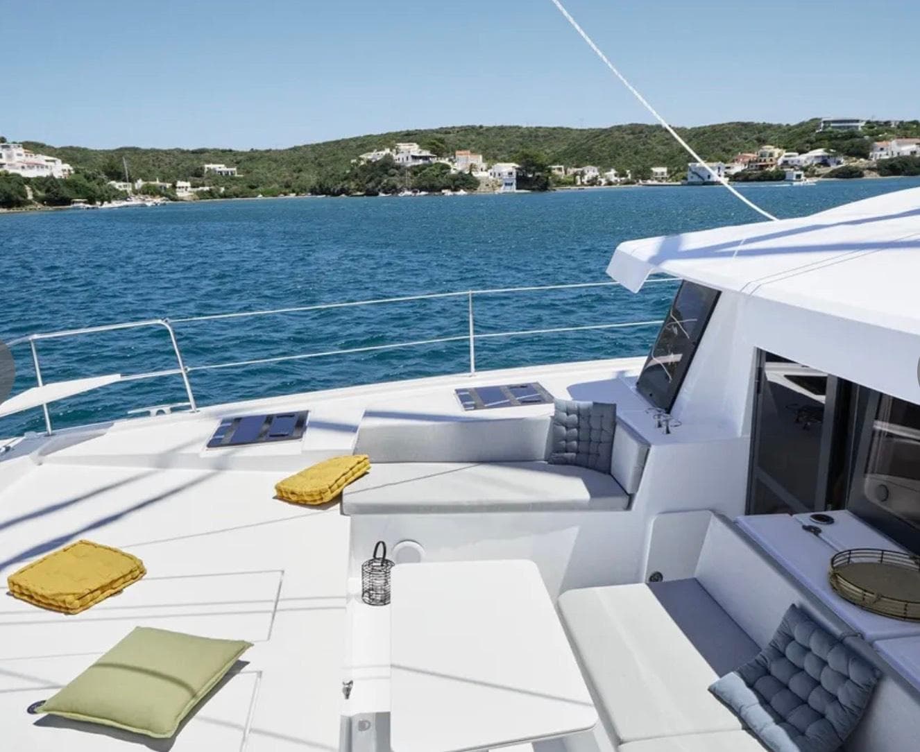 Luxurious Bali 4.4 catamaran deck with cushions, overlooking serene blue waters, 2023 model.