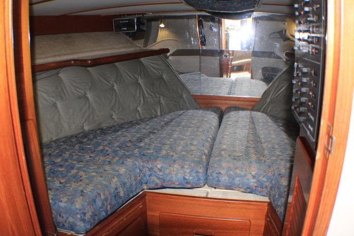 1988 Tollycraft 30 Sport Cruiser cabin with blue patterned bedding and wood accents.