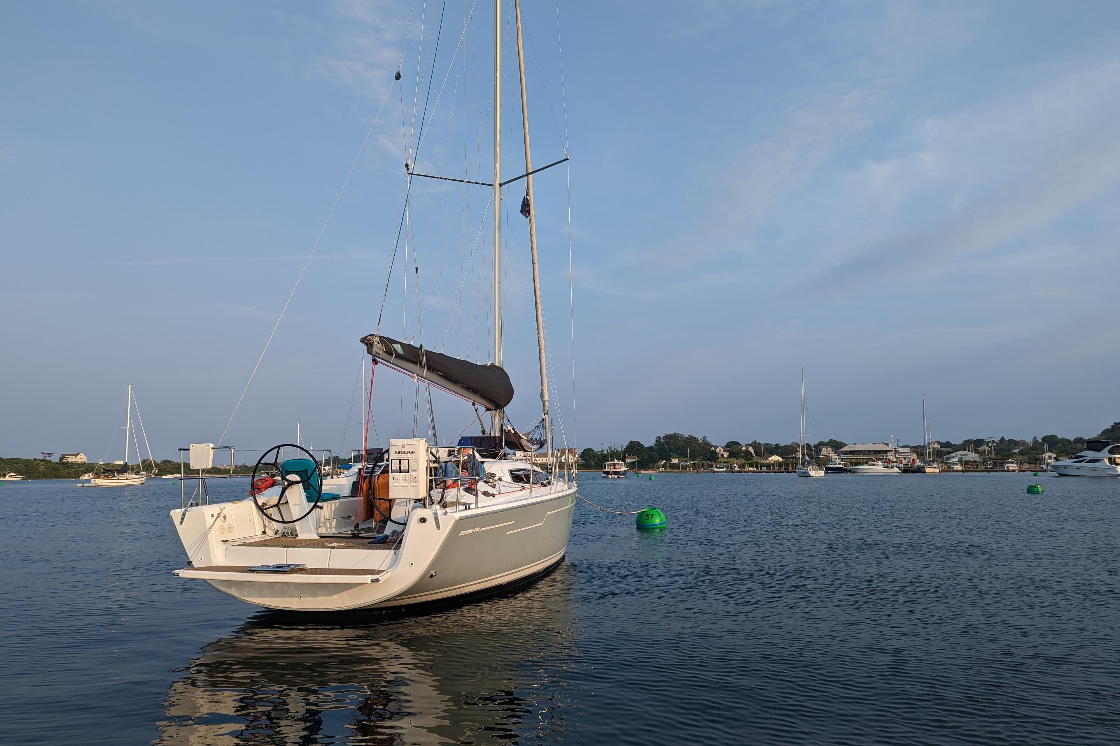 2019 Dehler 34c sailboat anchored in a calm harbor with clear skies.
