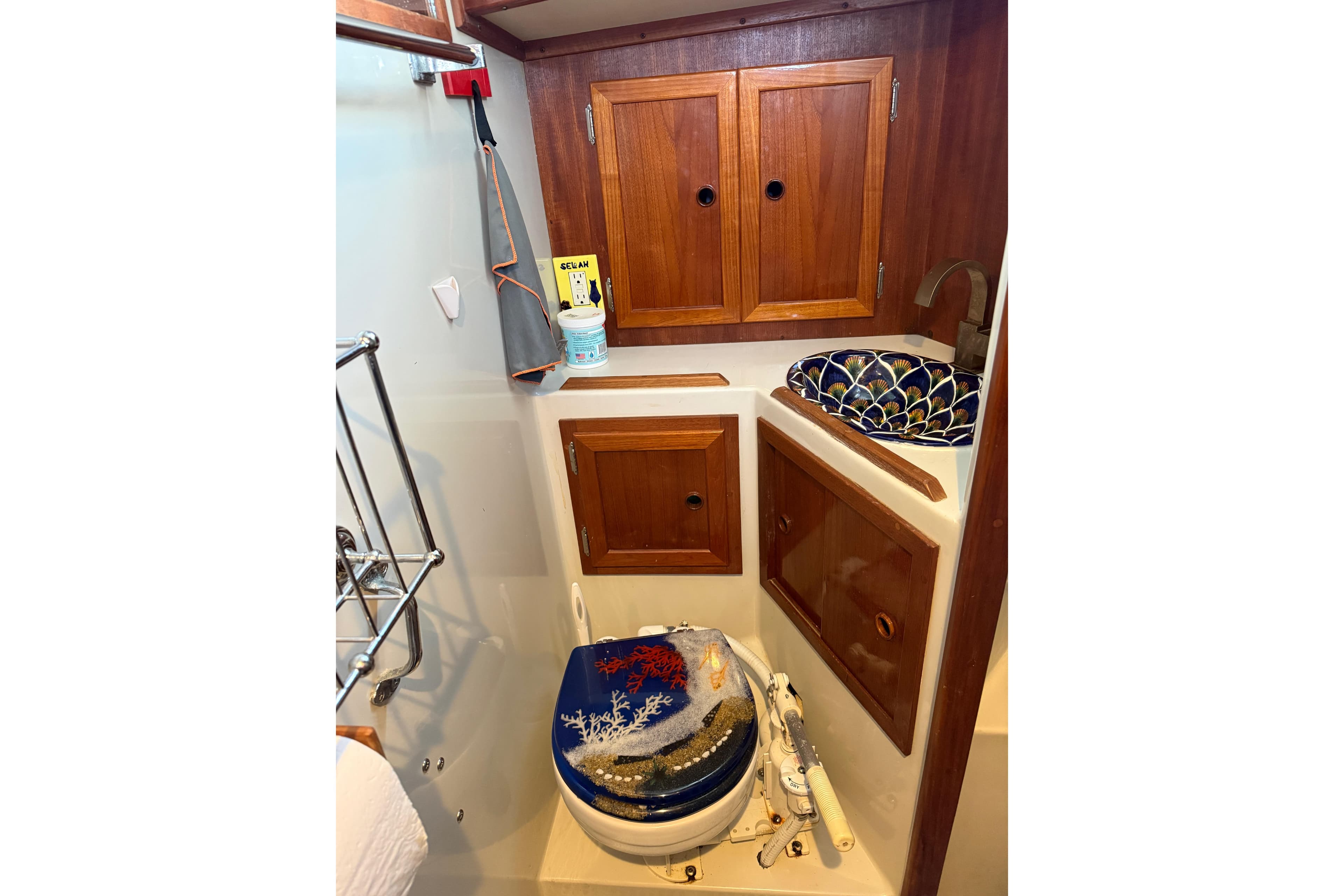 1983 Valiant Cutter boat bathroom with wooden cabinets and decorative sink.